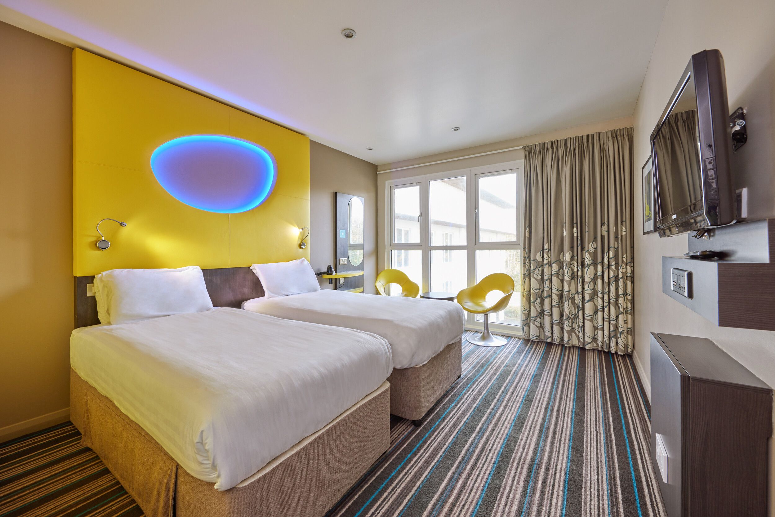 A twin bedroom with TV in our Wave Hotel Apartments at Bognor Regis.