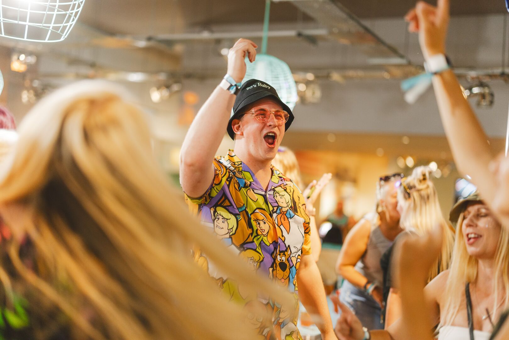 A close-up of a man singing with his hands in the air during Bottomless Brunch at Minehead resort.
