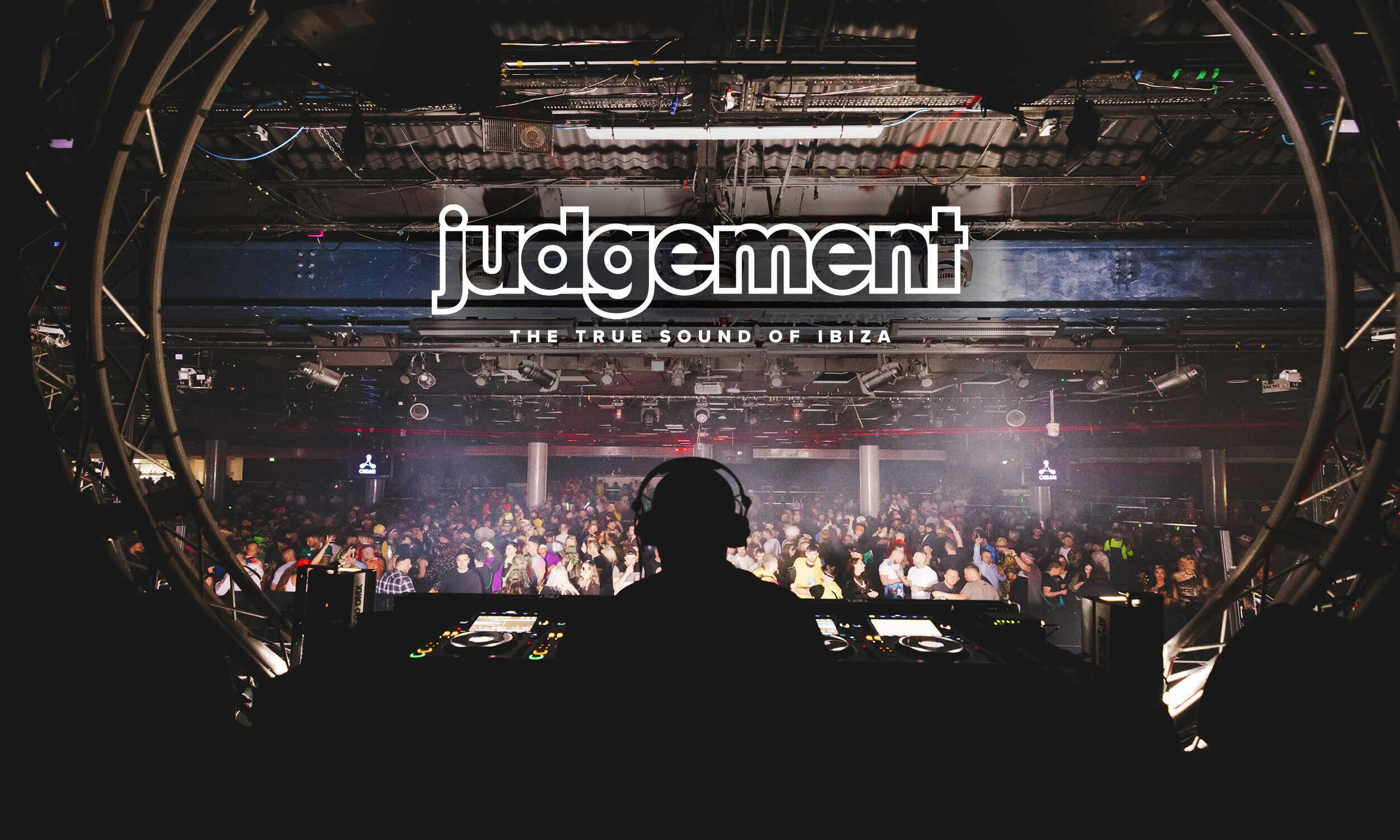 DJ silhouetted against a packed dancefloor at a Judgement club night event, with the brand logo and tagline "The True Sound of Ibiza" displayed above the crowd.