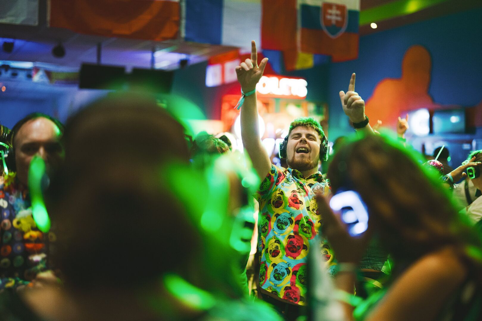 A close-up of a man in the crowd, singing and dancing along to the Silent Disco.