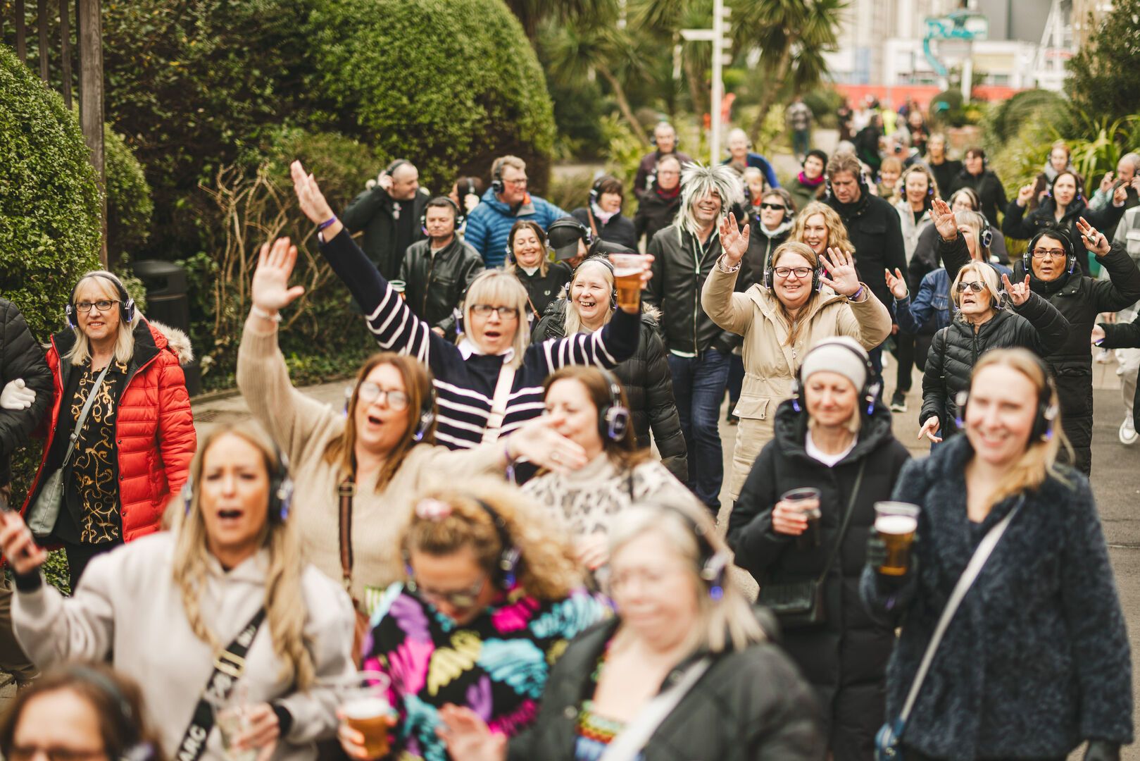 A large crowd walk, dance and sing together excitedly during the Soul Stroll activity at Butlin's Big Weekenders.