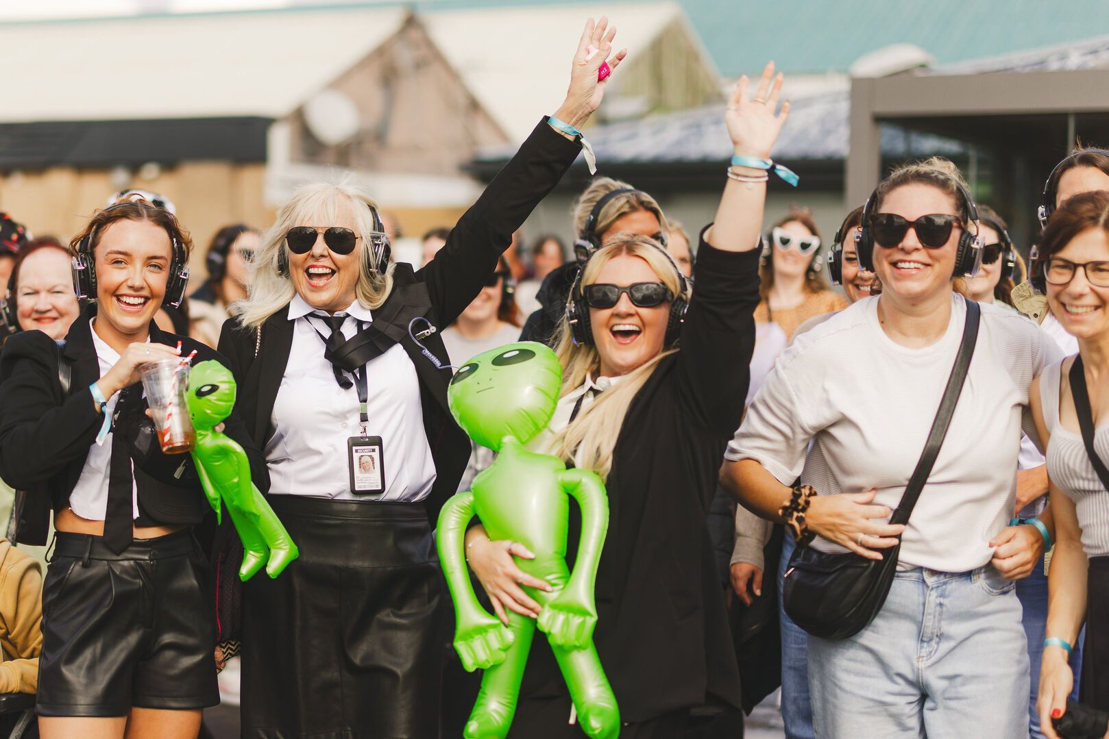 A photo of the crowd during Soul Stroll, with their hands in the air while posing for the camera.