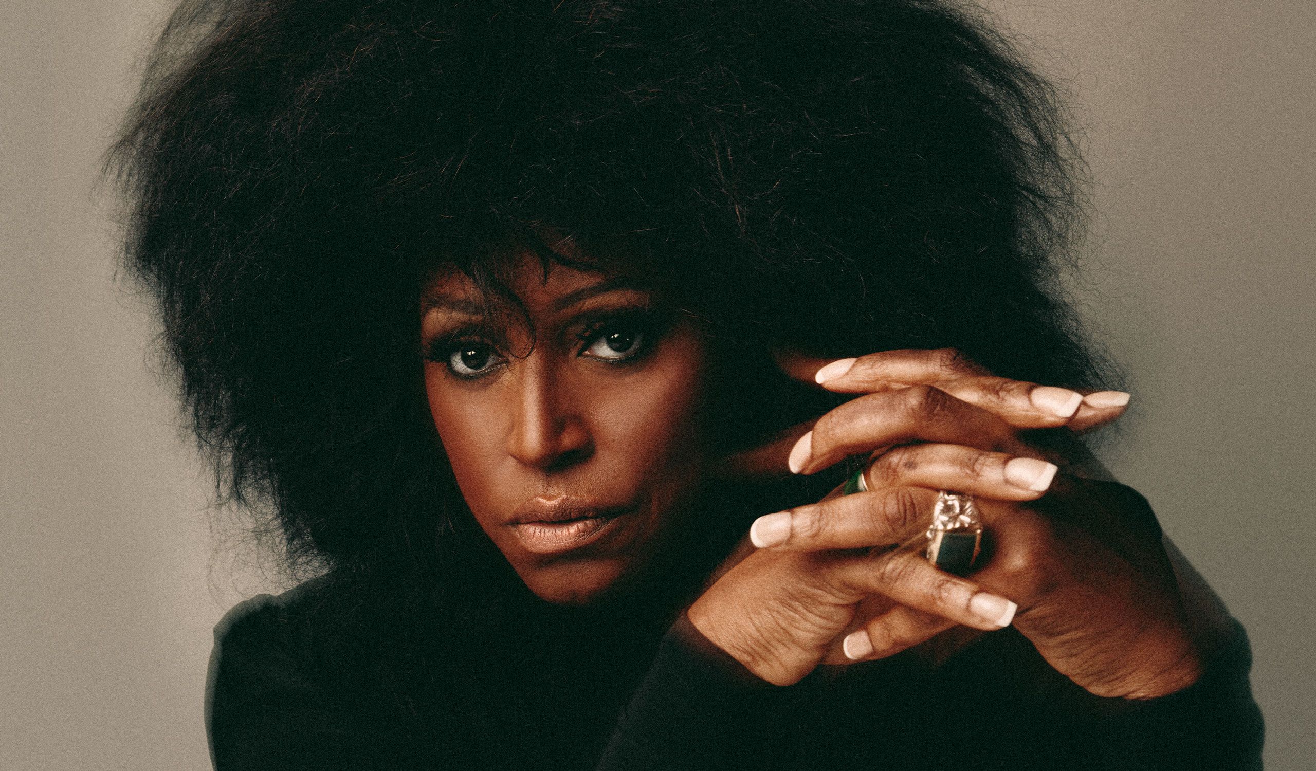 A close-up shot of Mica Paris. She's wearing a black top and is also wearing a large ring.