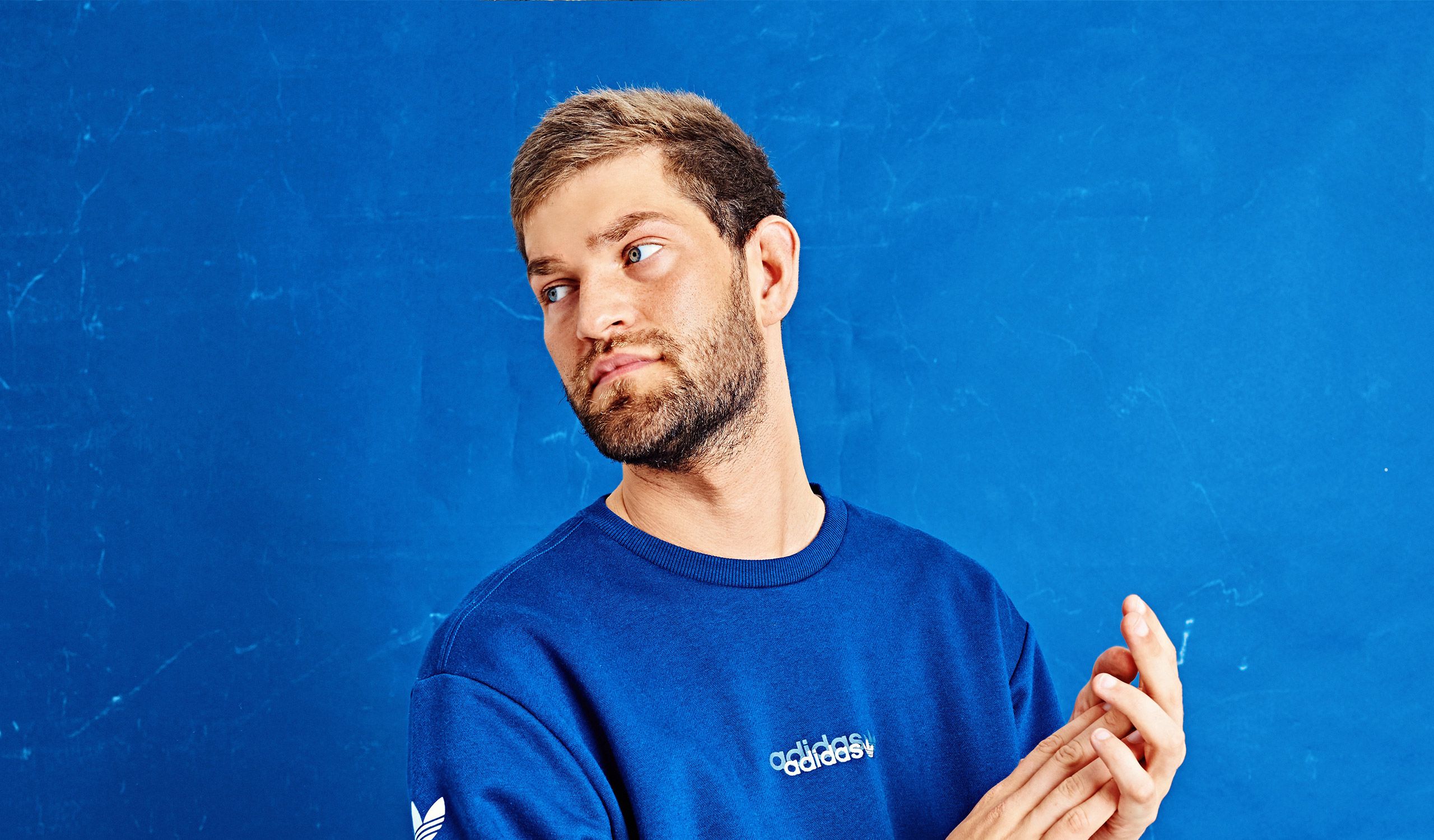 Close-up shot of Nathan Dawe looking away from camera in a blue sweatshirt.