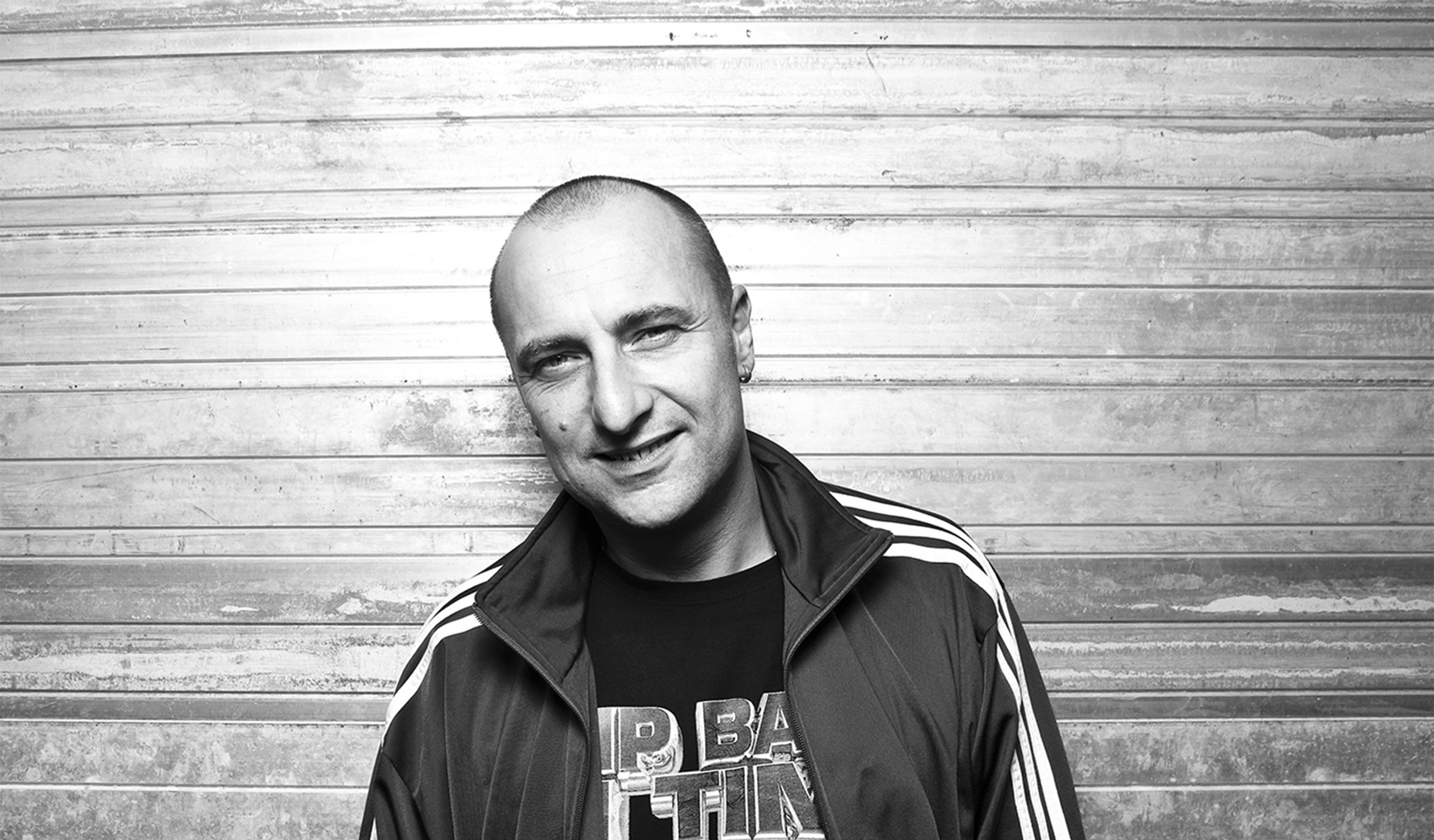 Black and white photgraph of Slipmatt. He's against a wooden background looking at the camera.
