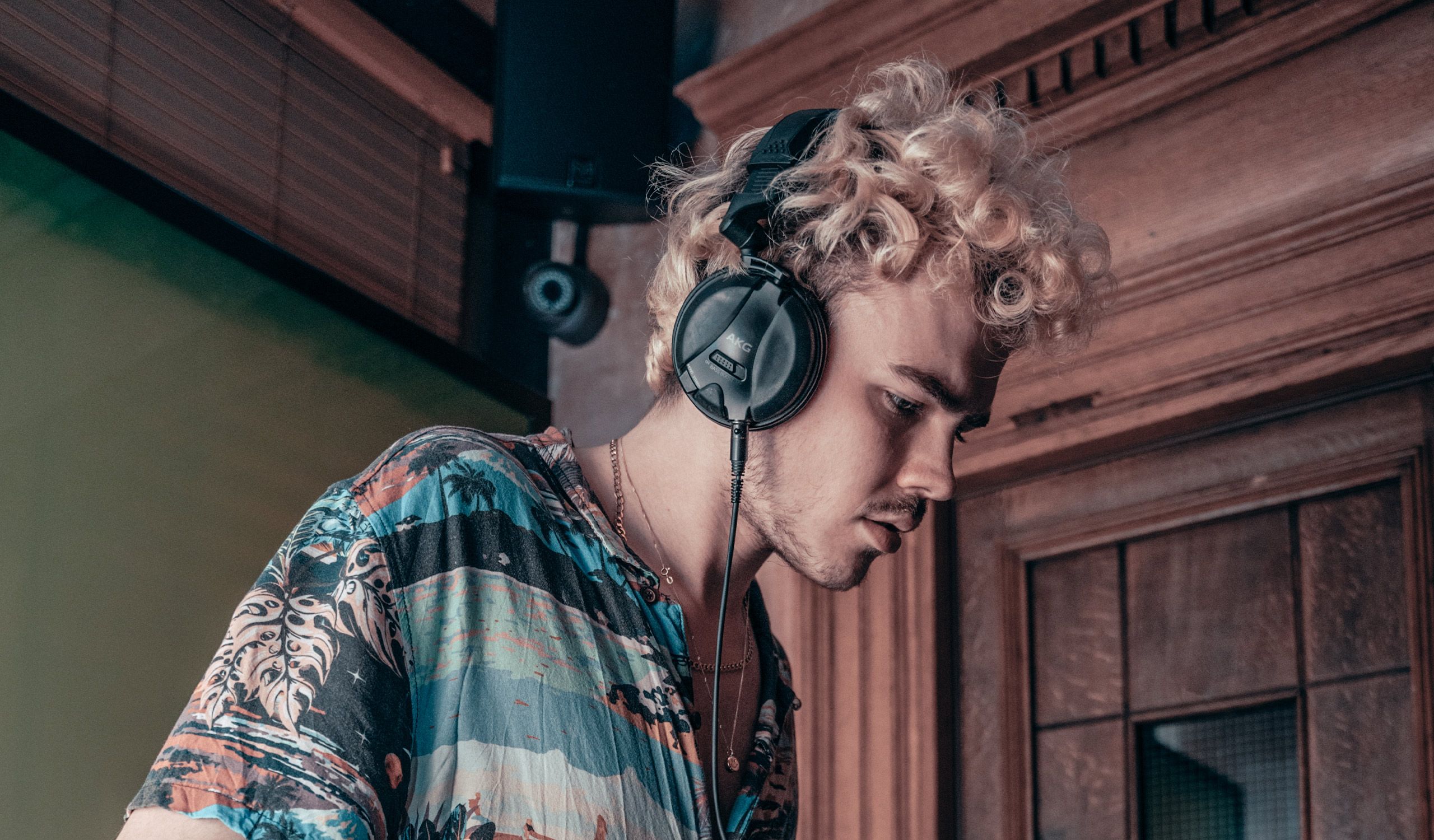 The DJ, Woody, playing his decks wearing a tropical shirt and wearing headphones.