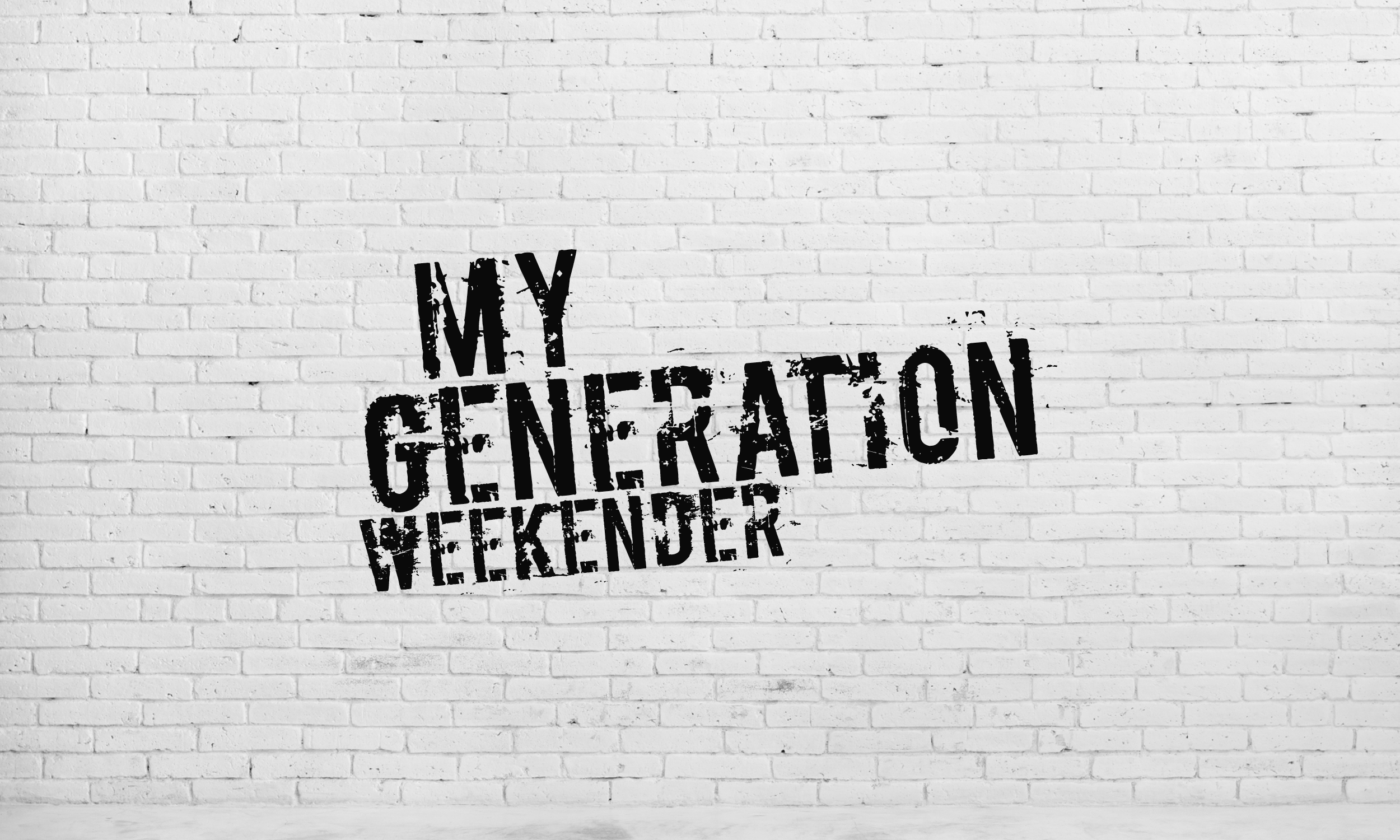A white brick wall with distressed stencil-style black text reading “MY GENERATION WEEKENDER.”