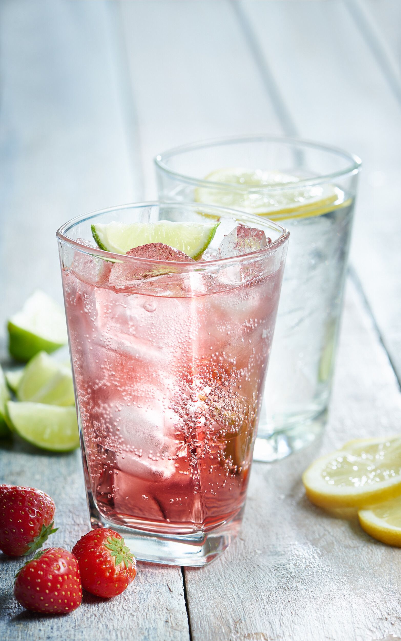 Two glasses of cocktail garnished with a slice of lemon.