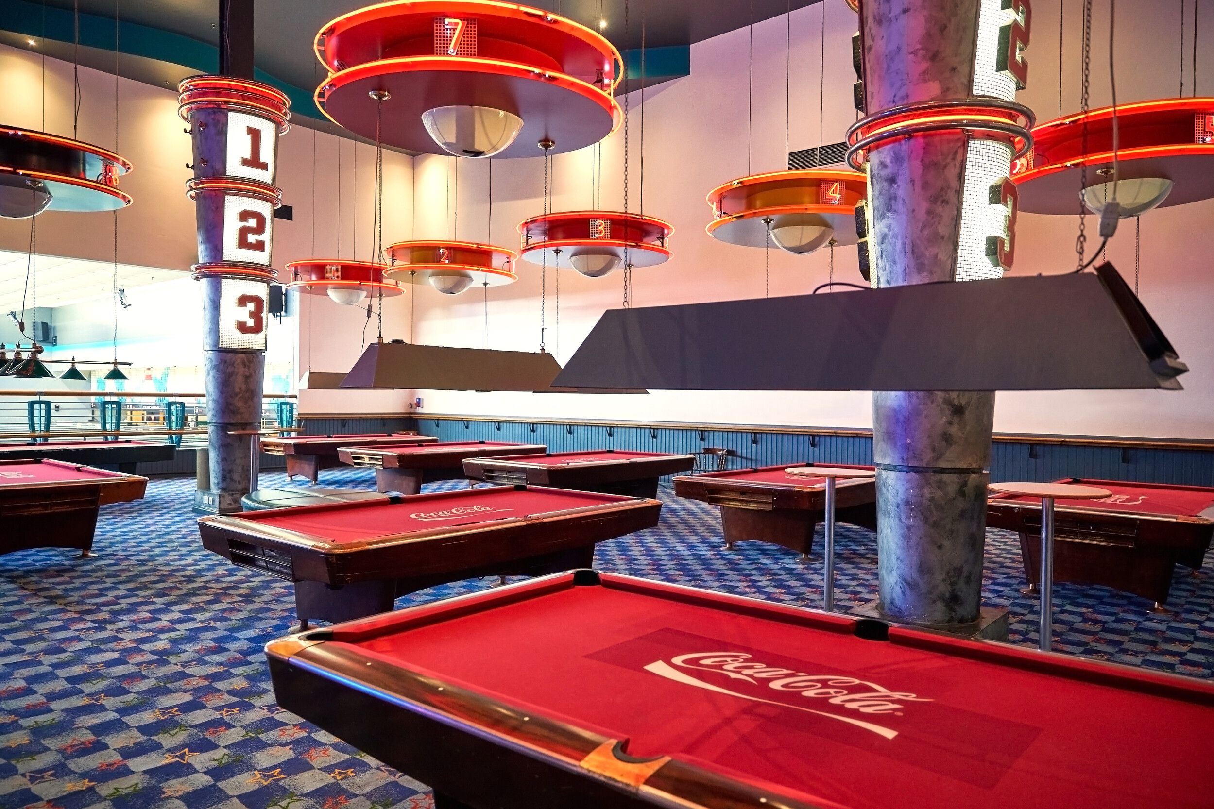 A set of red billiard tables with a Coca-Cola logo.
