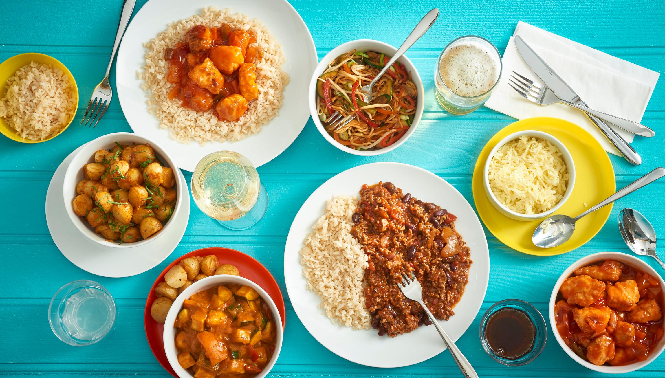 A table filled with foods such as potatoes, fillet and noodles.