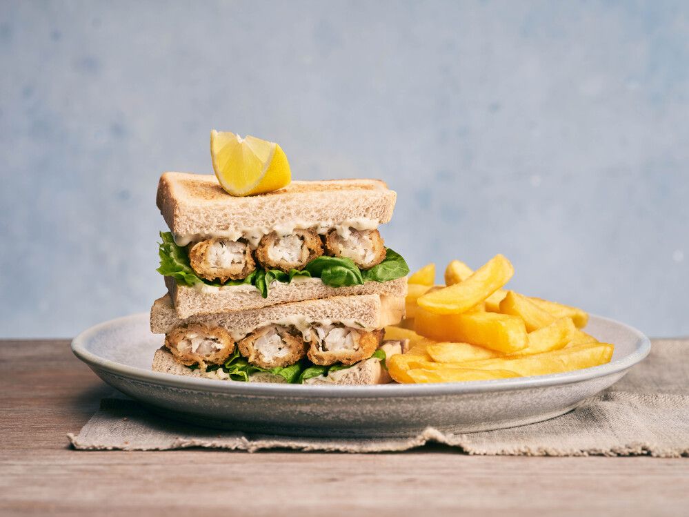 A plate of club sandwich with a side of chips.