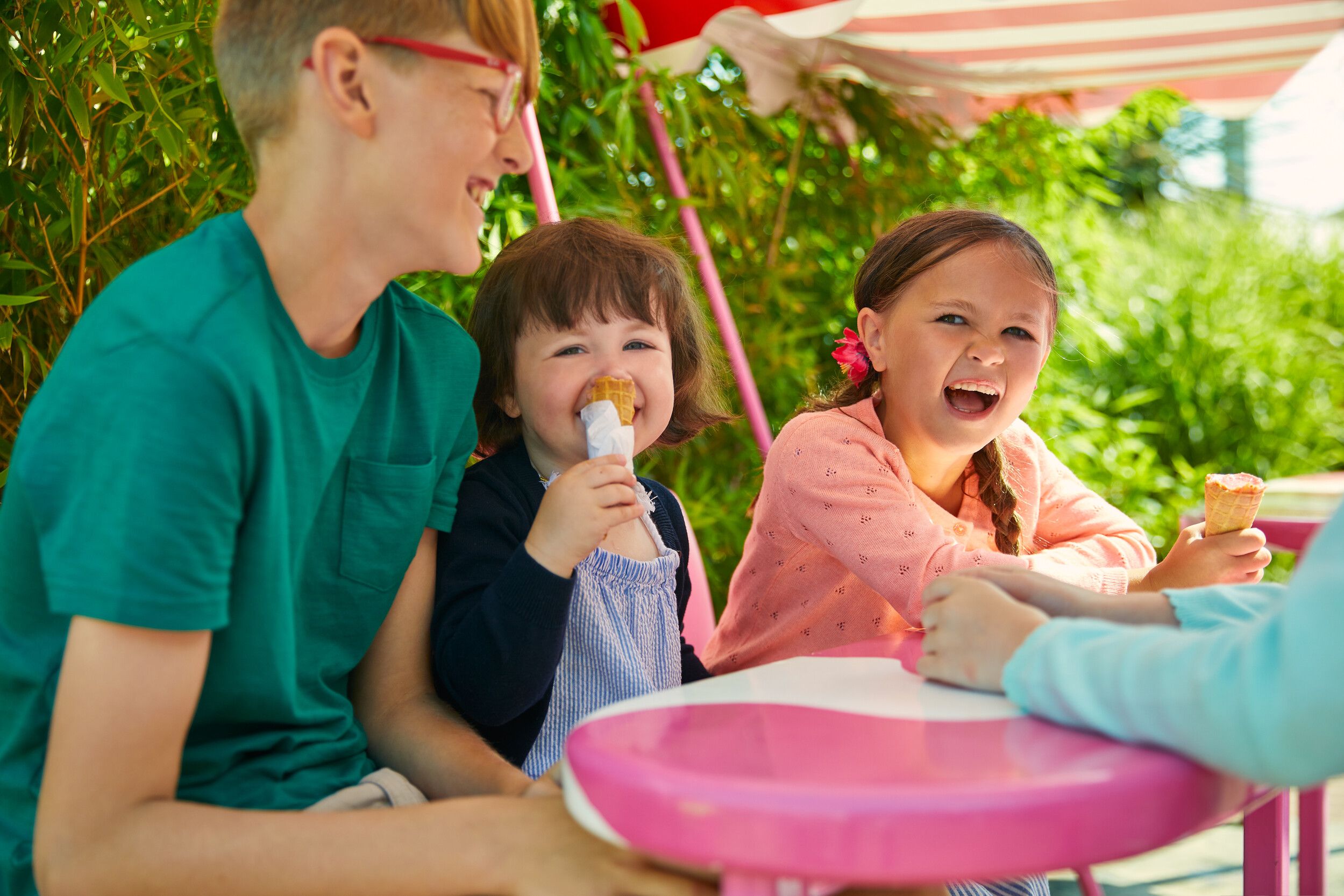 Two little girls enjoying an ice cream cone outdoors.