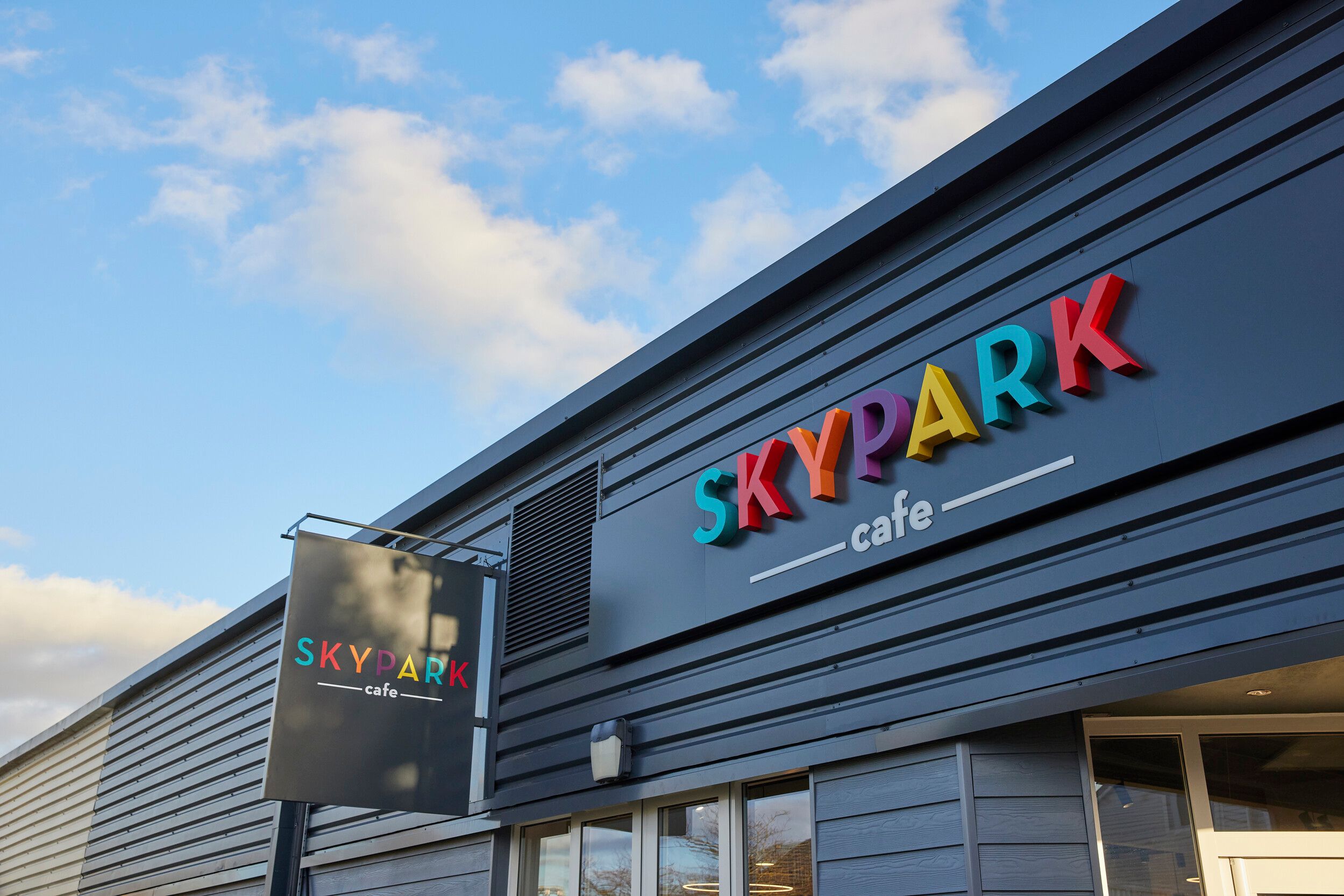 A colourful logo of SKYPARK cafe.