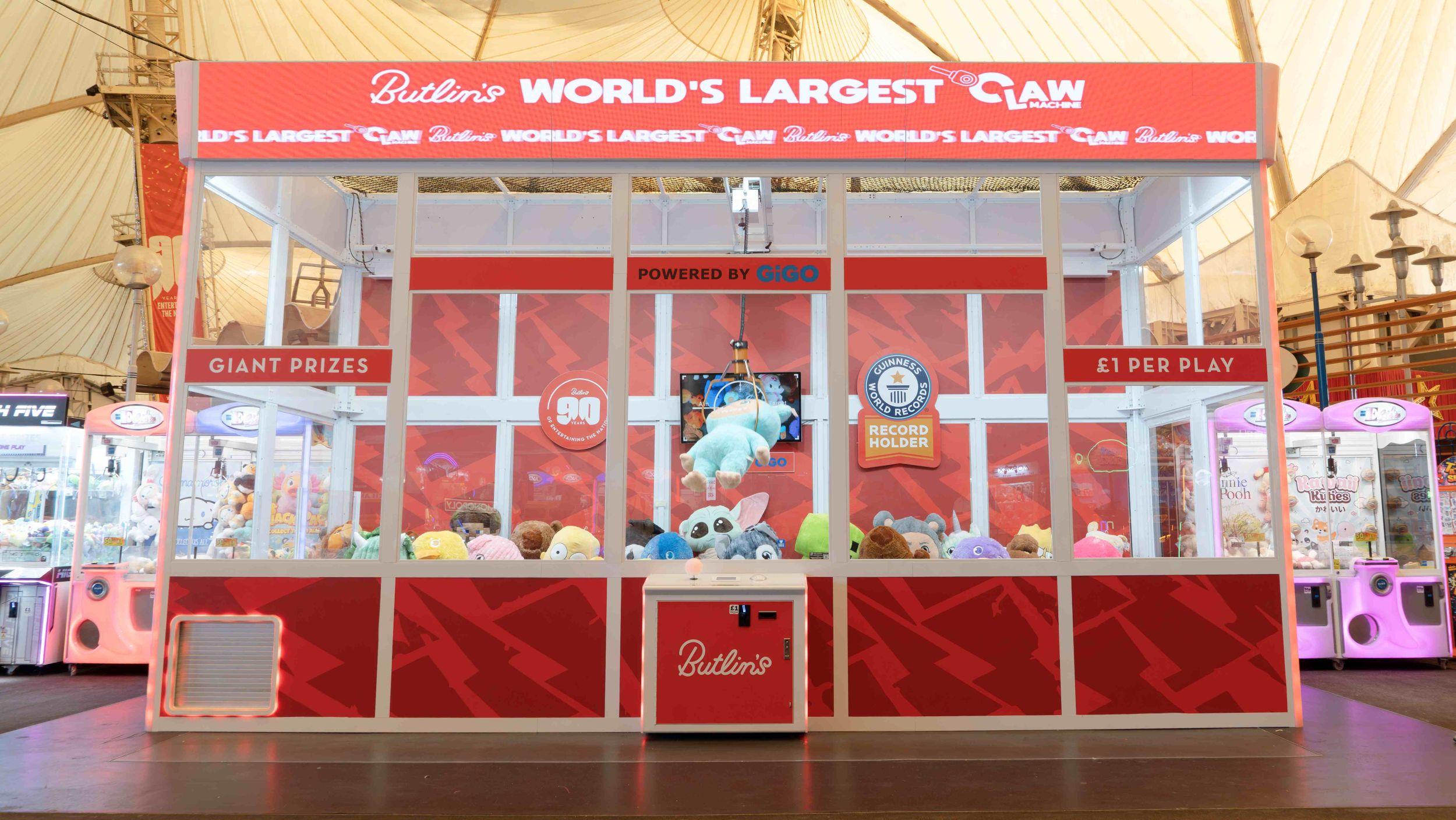 Butlin's World's Largest Claw Machine, a Guinness World Records-certified giant claw arcade game filled with plush toys, with signage reading "Giant Prizes" and "£1 Per Play."