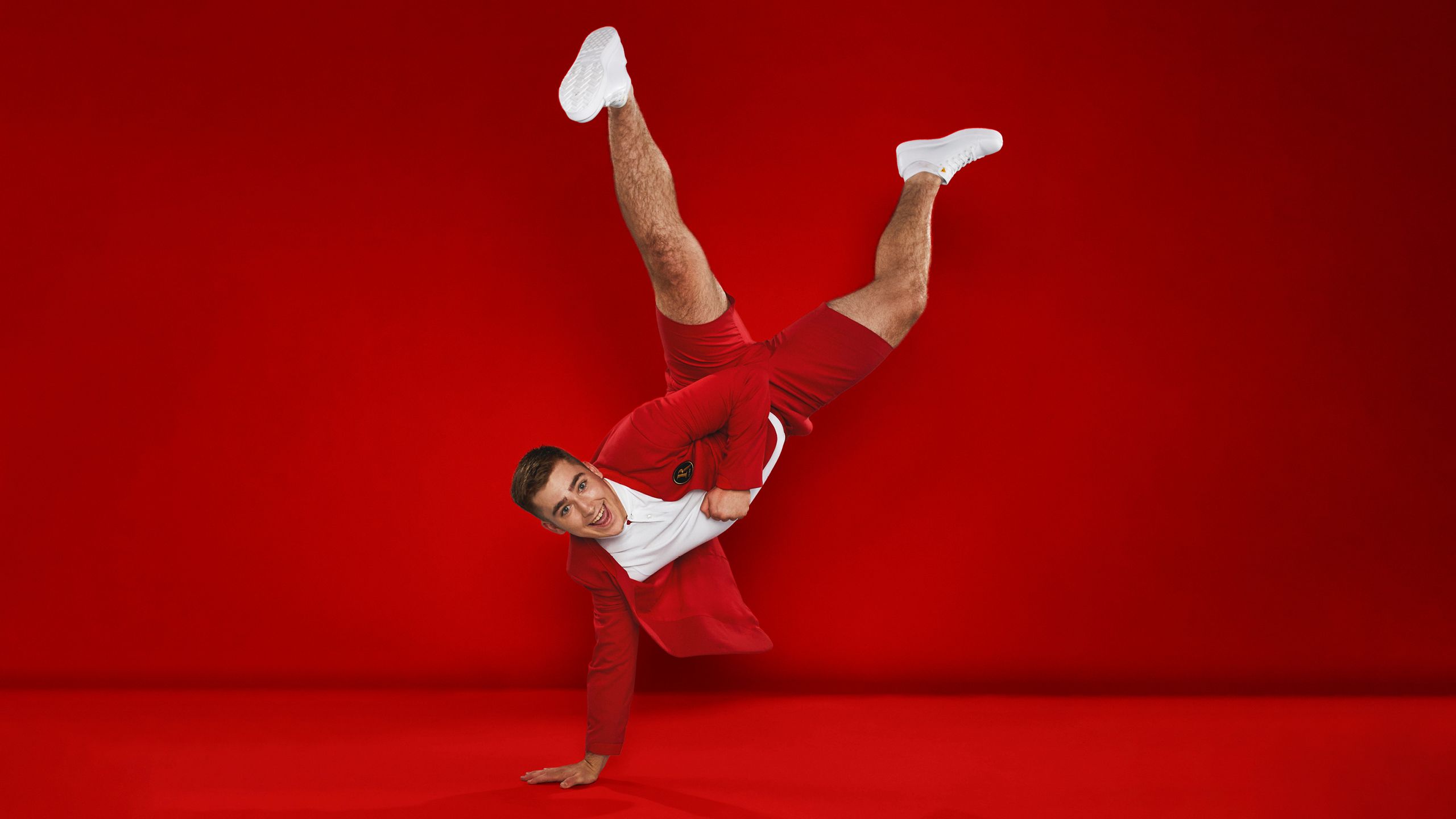 A Redcoat poses for the camera by doing a one-handed hand-stand.