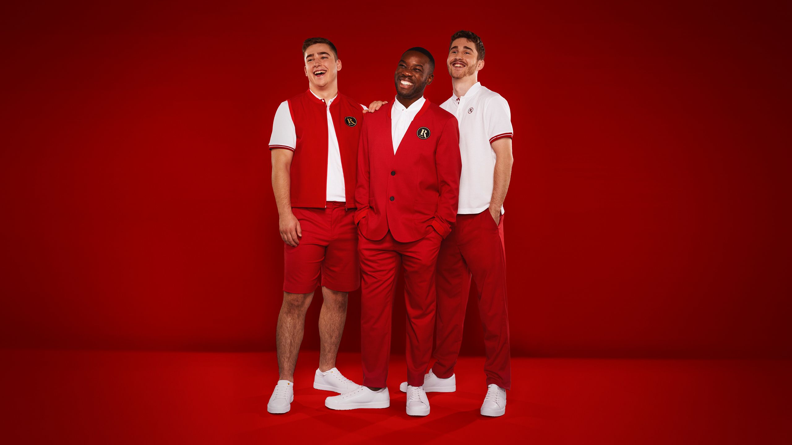 Three Butin's Redcoats pose for the camera together, against a red backdrop.