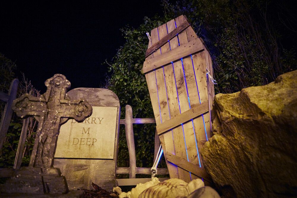 A fairground at a Butlin's resort, decorated in a spooky graveyard theme.