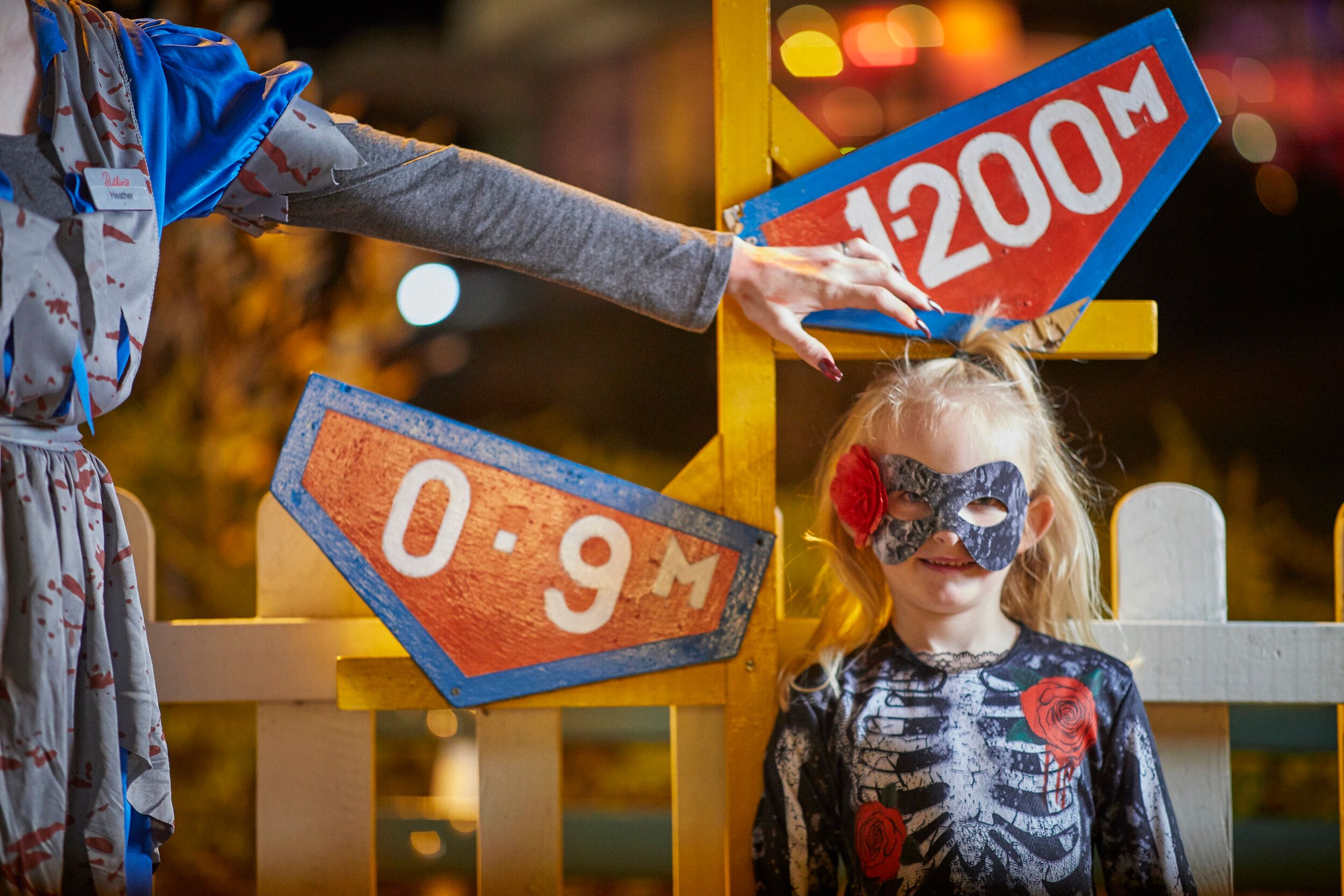 A young girl dressed as a Skeleton poses for the camera.