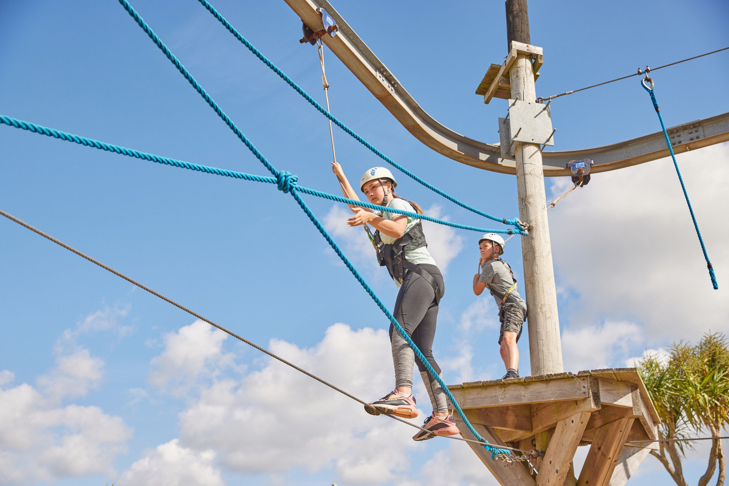 A woman focused on finishing the obstacle in High Ropes.