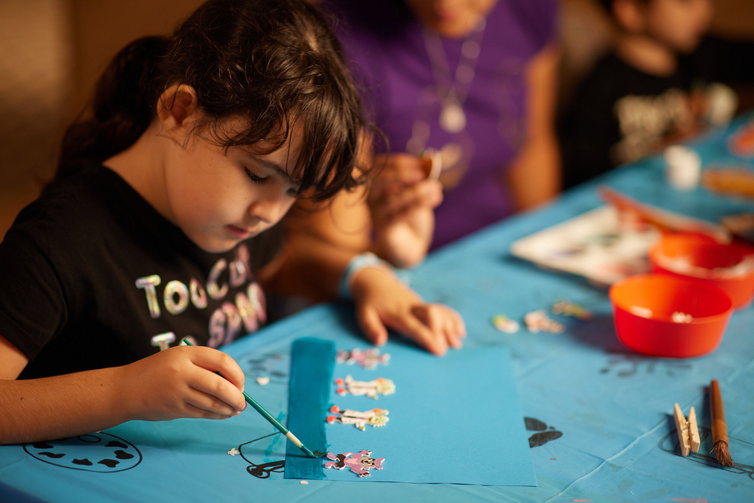A little girl painting some artwork.
