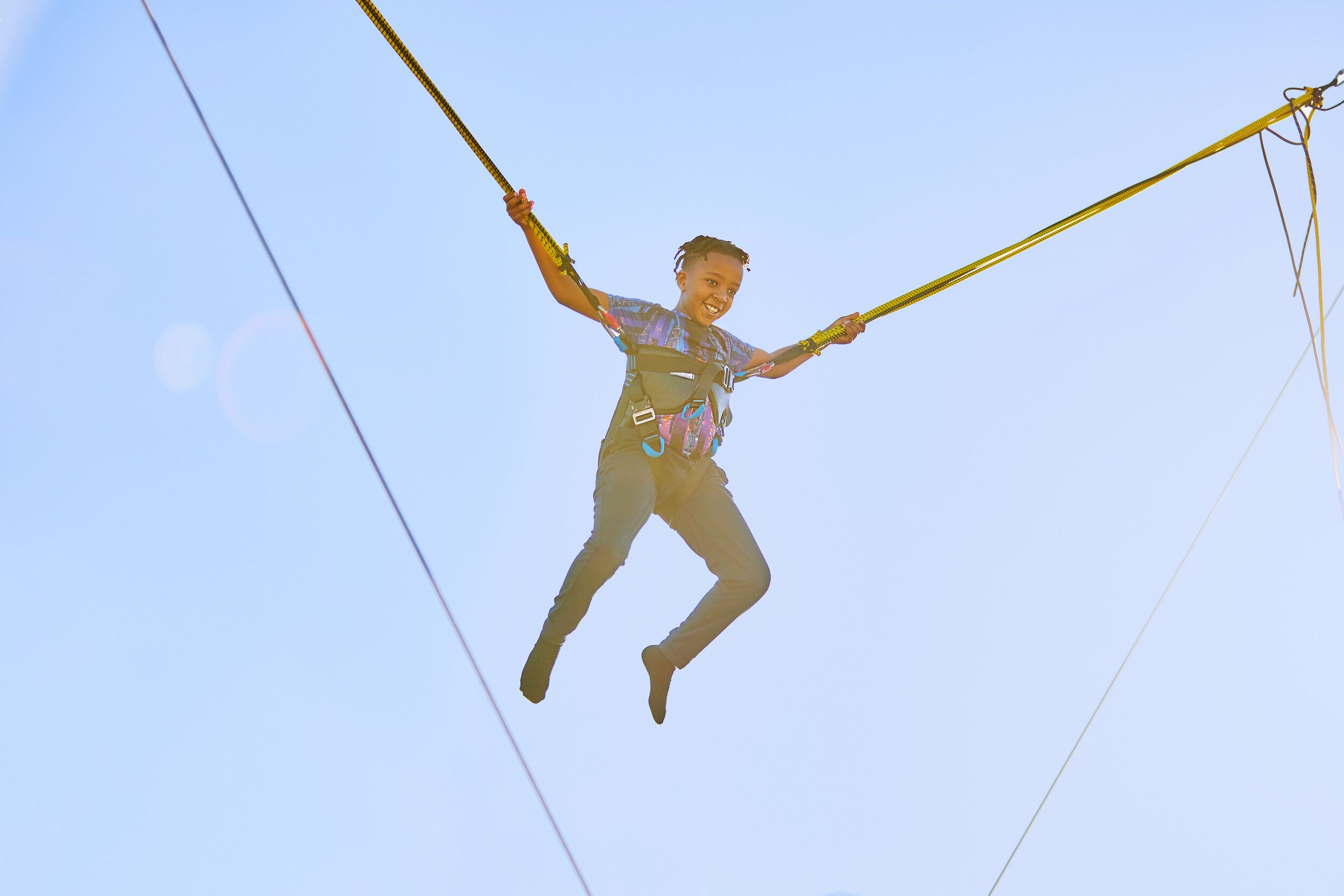 A boy in the air while jumping on the trampoline.