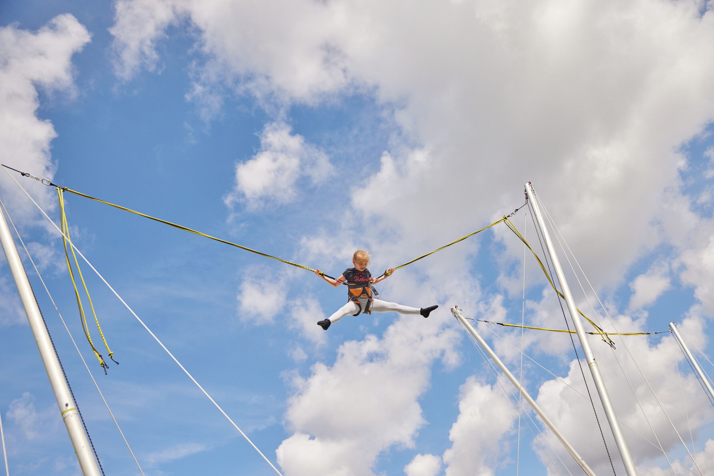 A girl in the air while jumping on the trampoline.