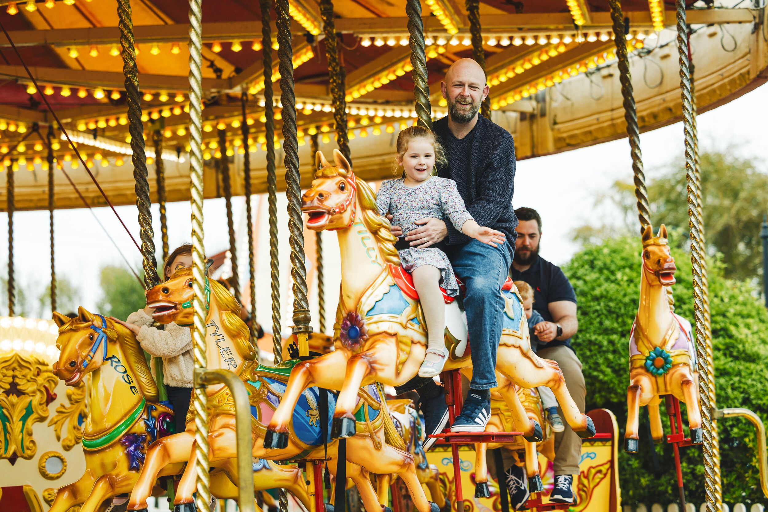A woman and a child riding the carousel at the fairground.