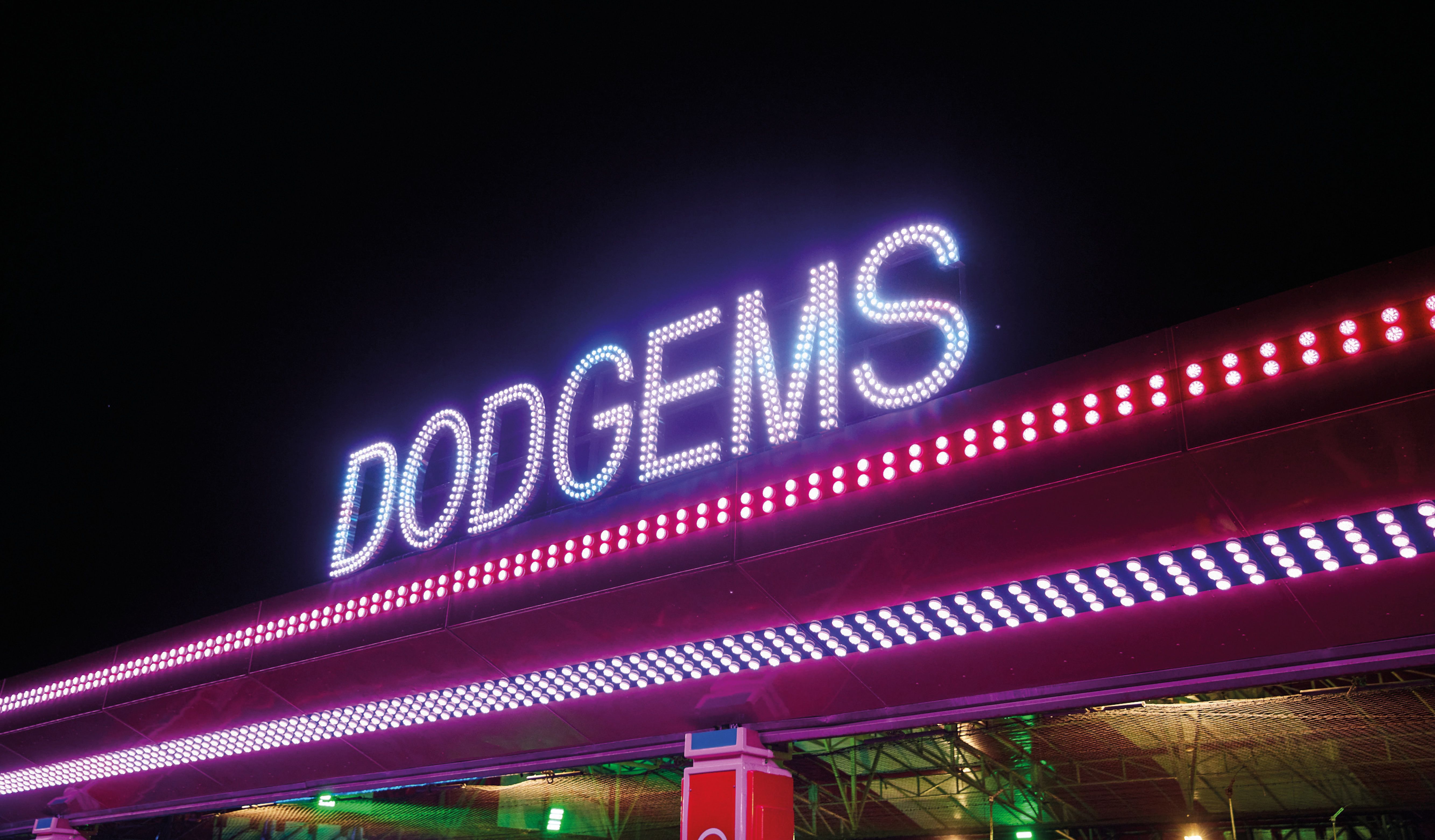 An illuminated signage saying "DODGEMS" at the fairground.