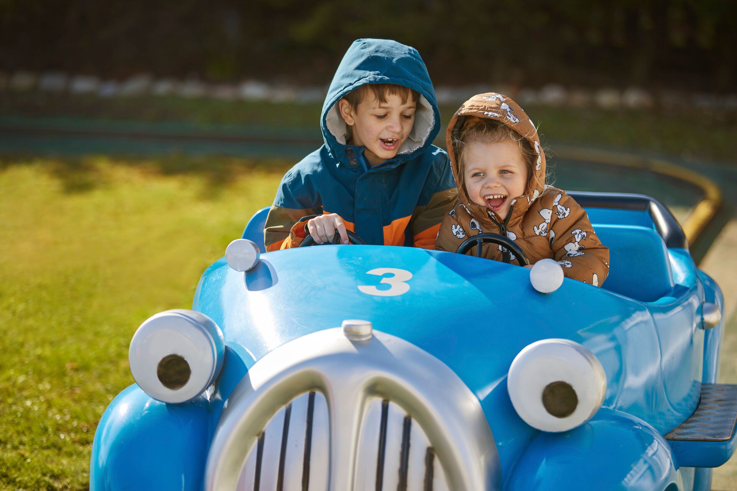 Two children enjoying a scrambler ride at the fairground.