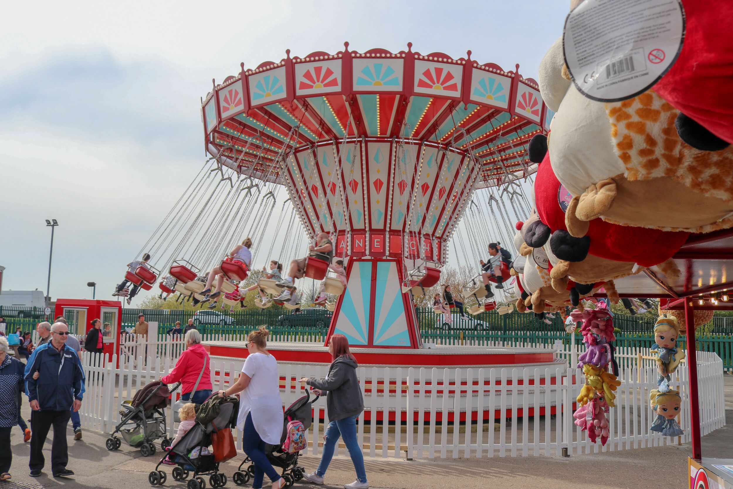 Guests walk through the Skegness fairground, while looking at the Chairoplane ride.