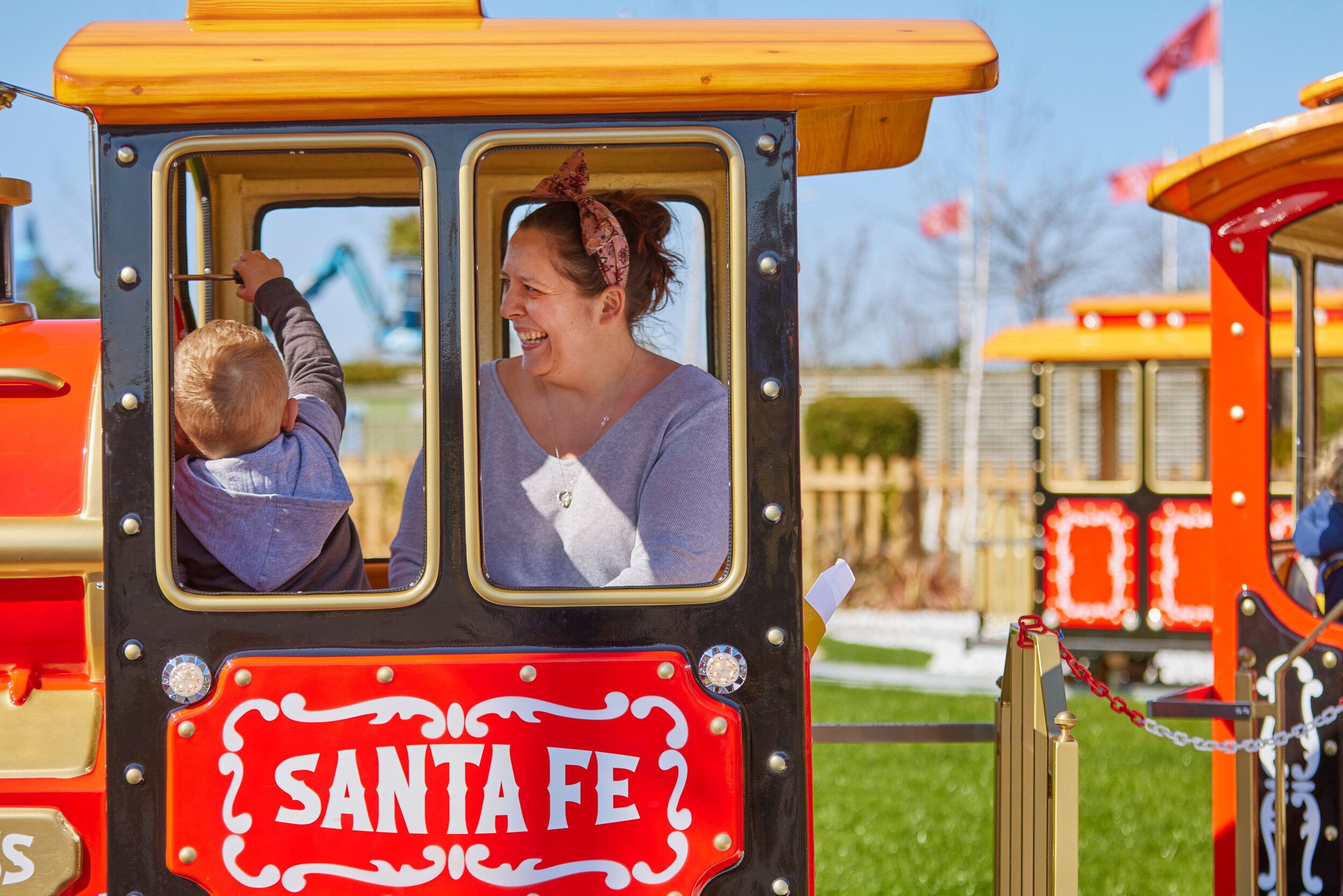 A mother and a child riding the Santa Fe Express train ride.