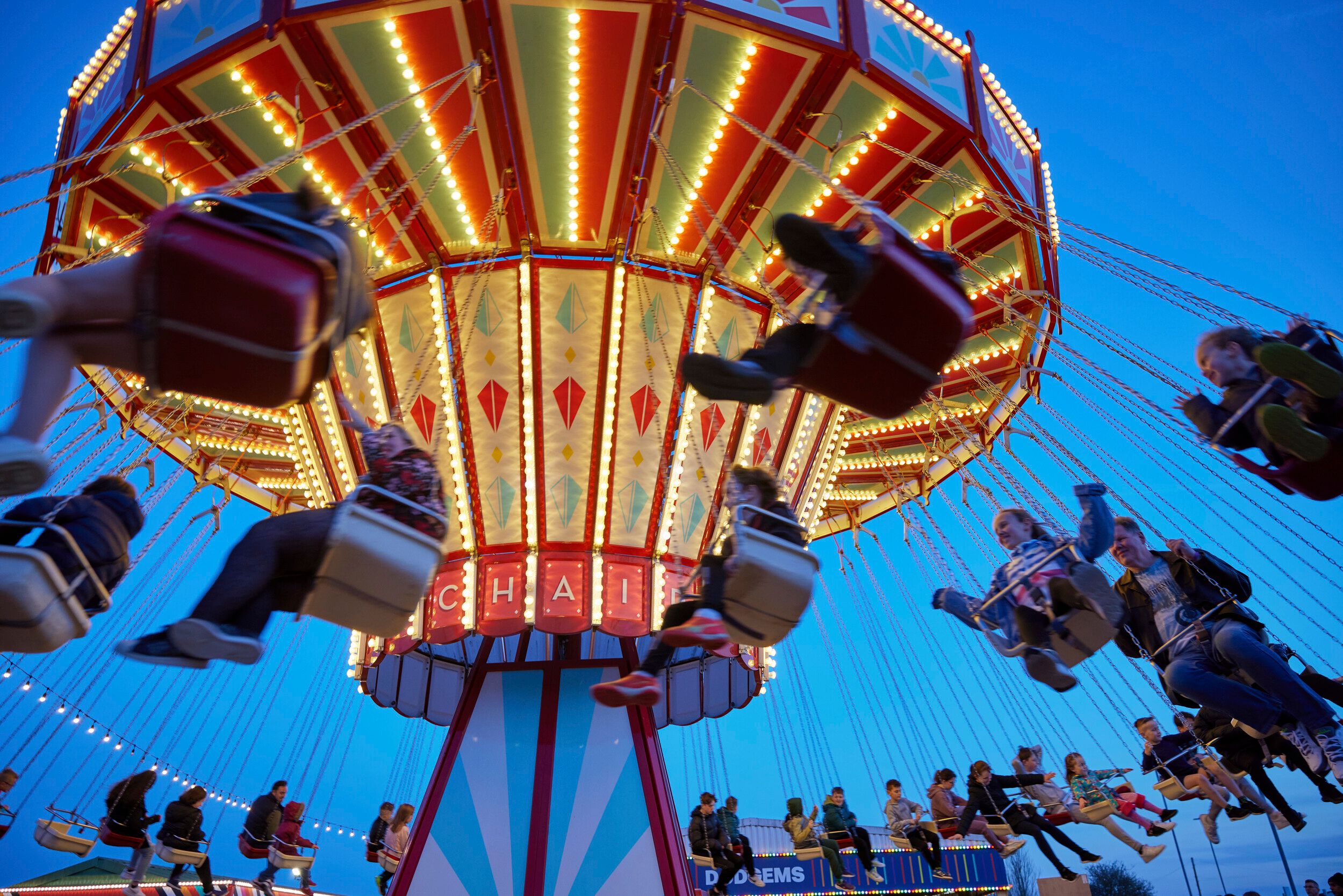 A photo of guests enjoying the Chairoplane ride at dusk.