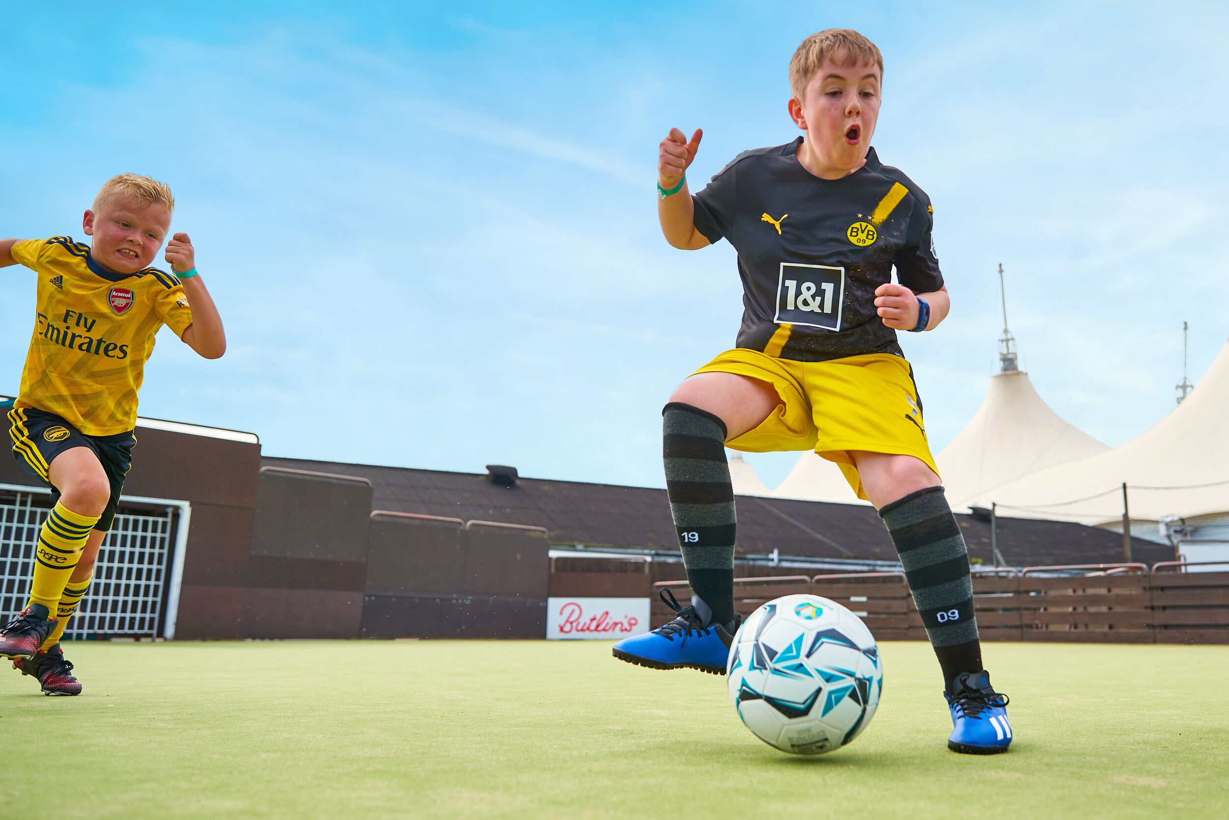 Two boys playing against each other in football.