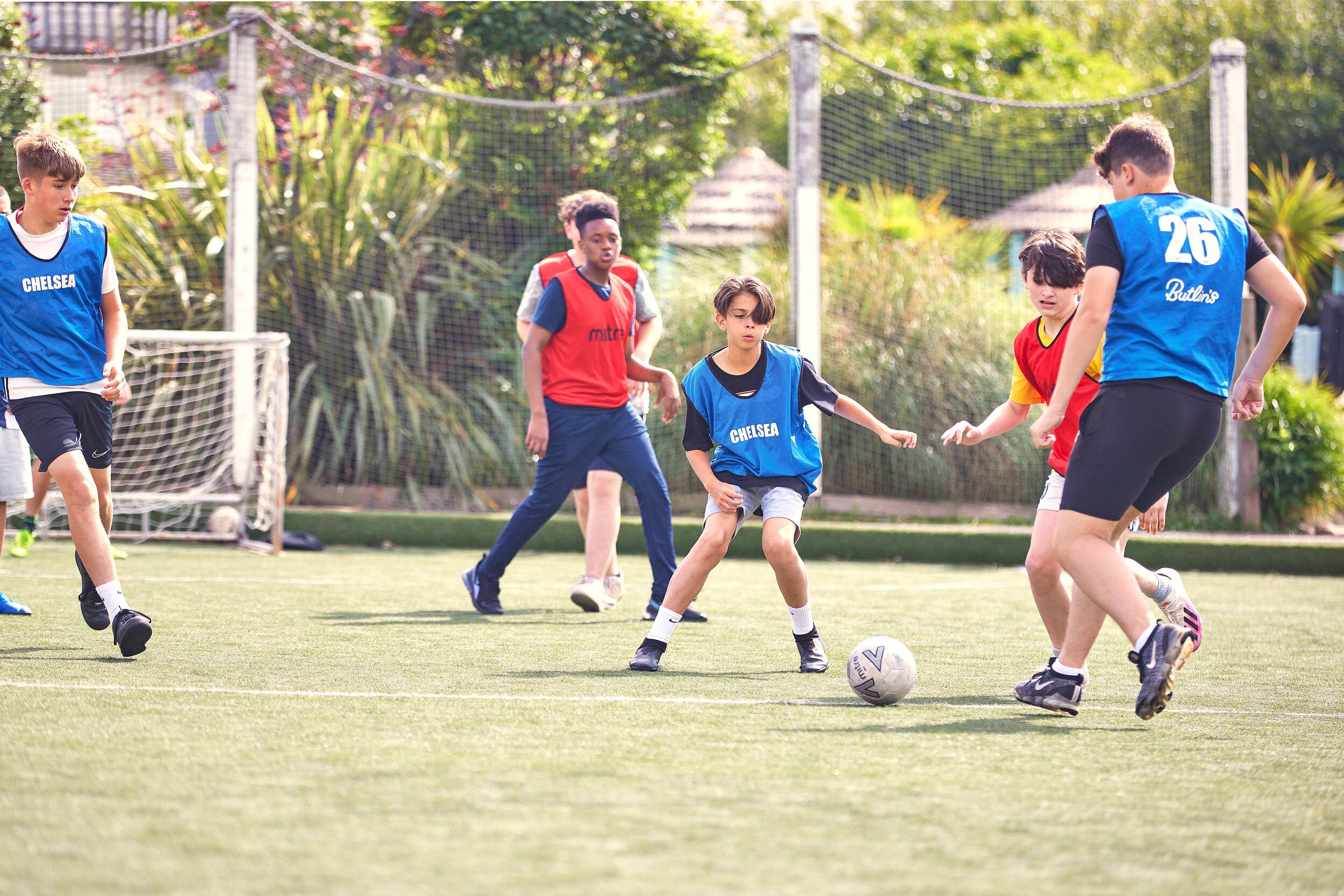 A group of boys playing football against each other.