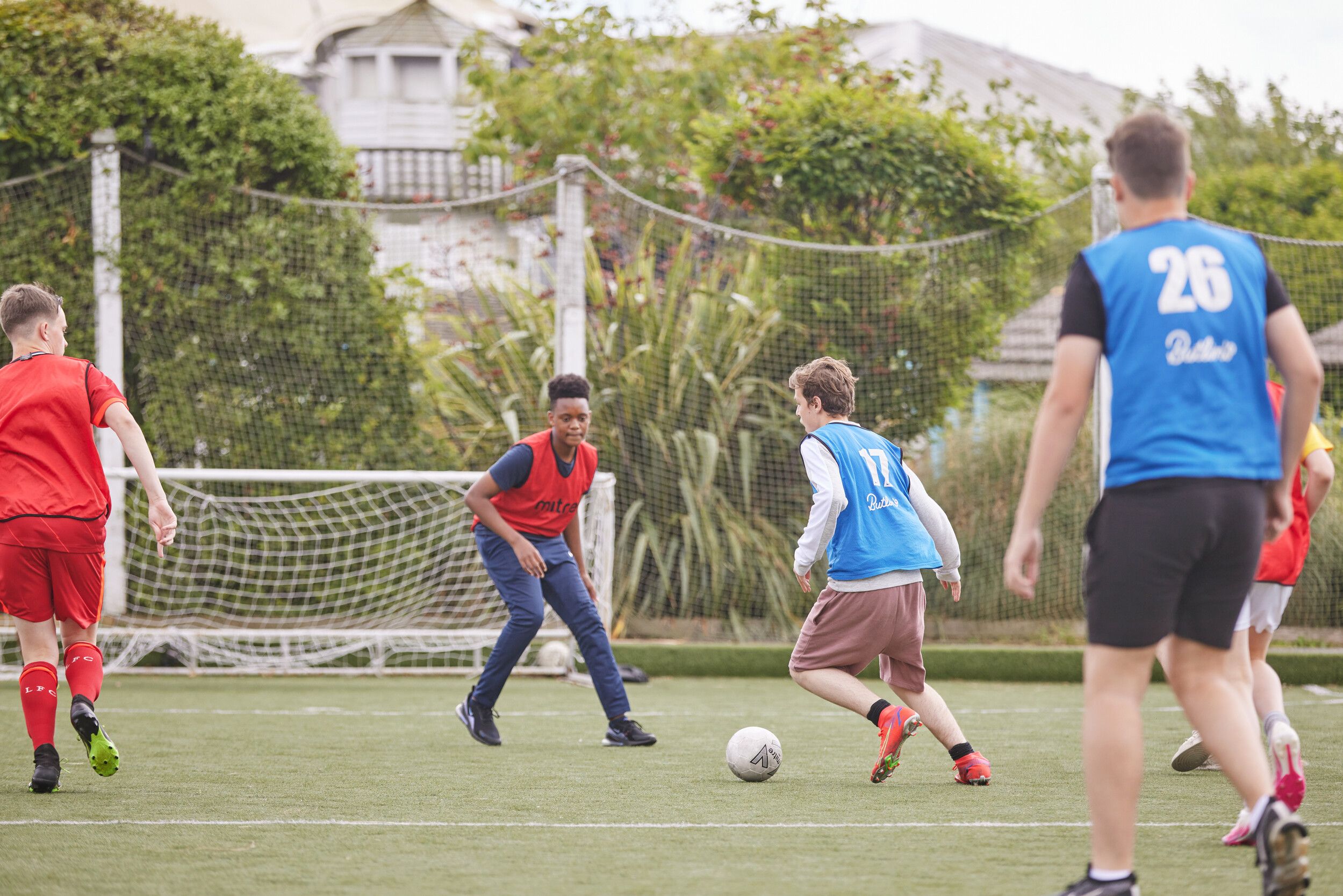 A group of boys playing football during the day.