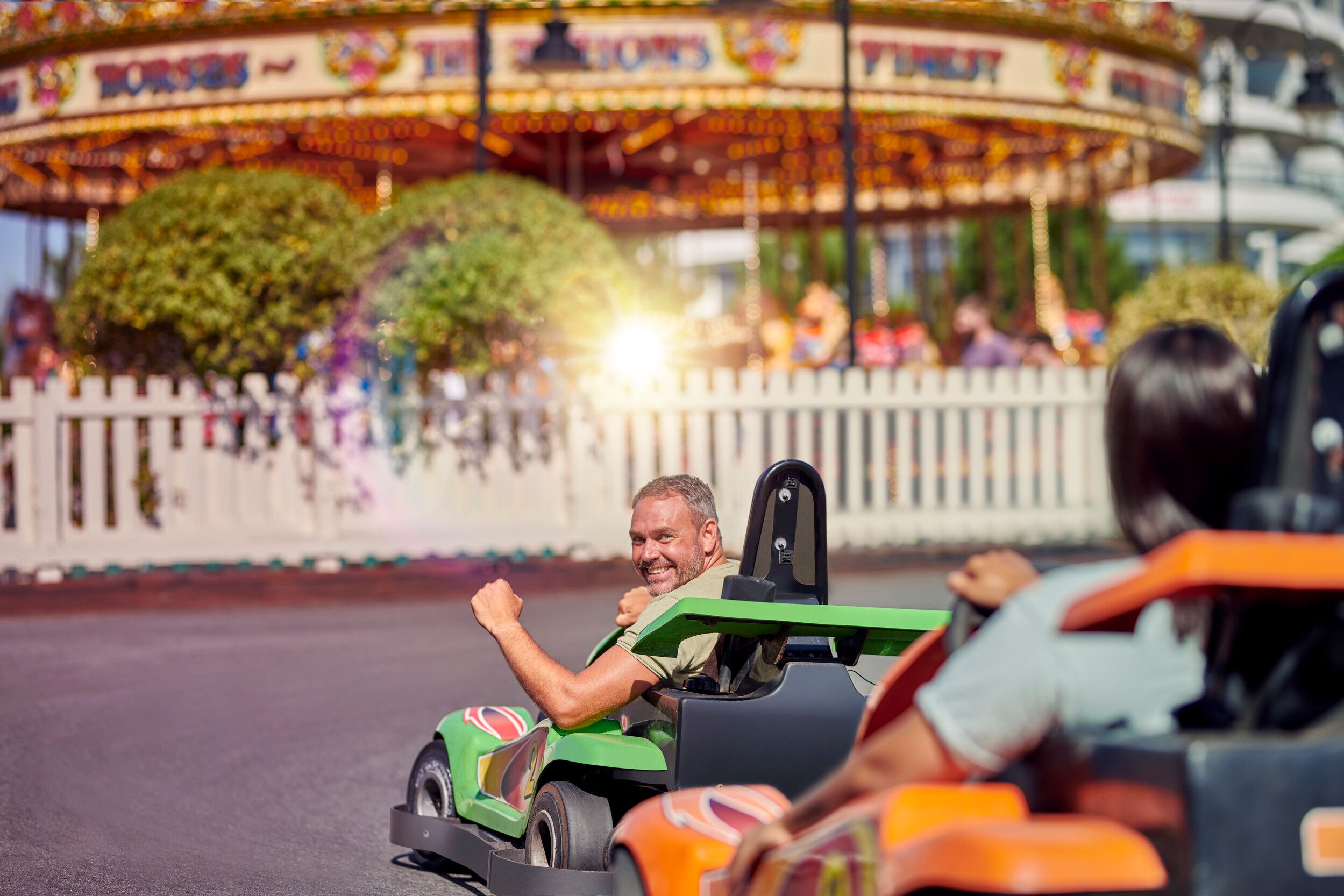 A man in a go-kart looking at the camera while celebrating.