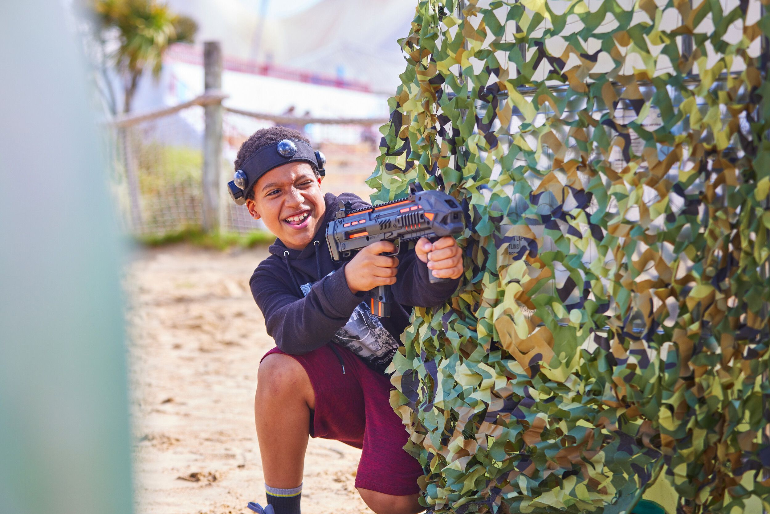 A boy shooting at someone in Laser Tag.
