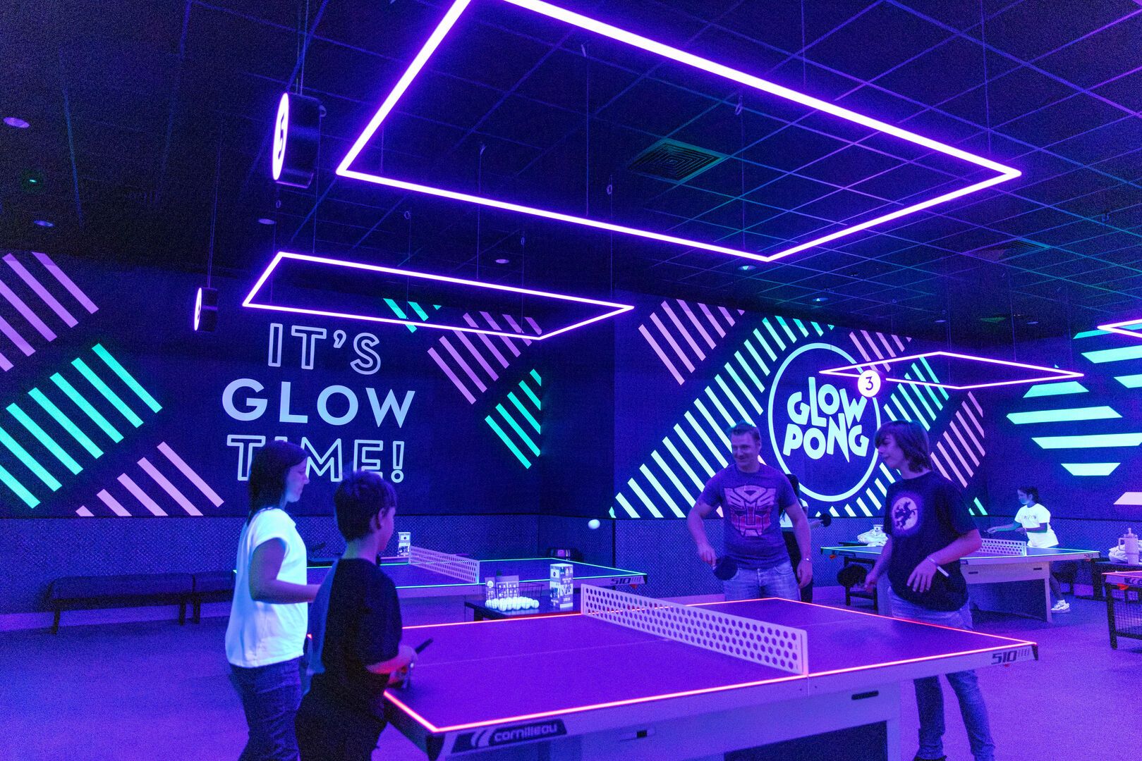 A family play Glow Pong together at Playxperience.