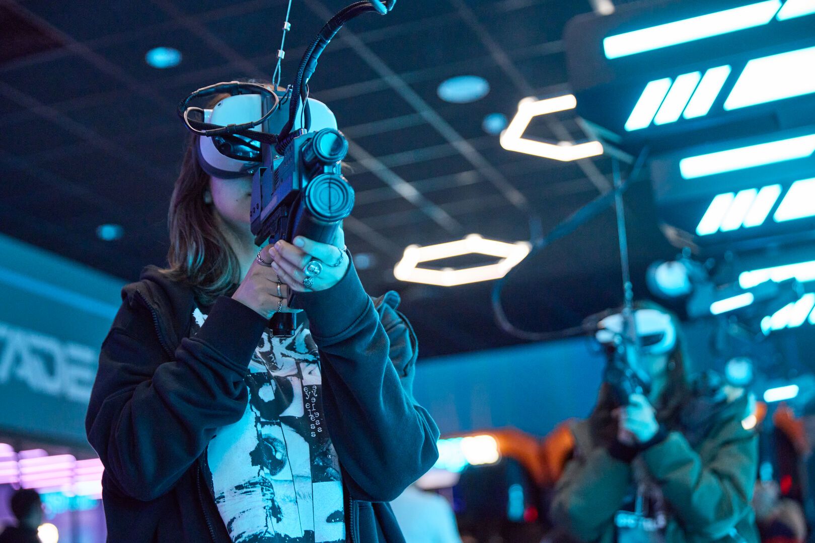 A girl wears a VR headset while playing a game in the VR-Cade at Playxperience.