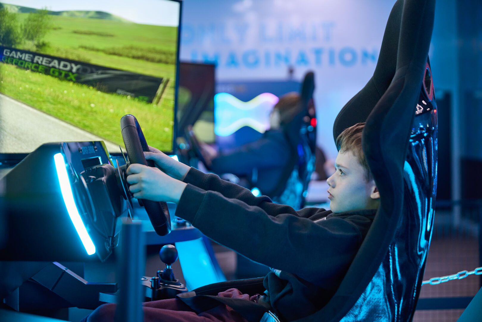 A young boy plays a driving game at the VR-Cade.