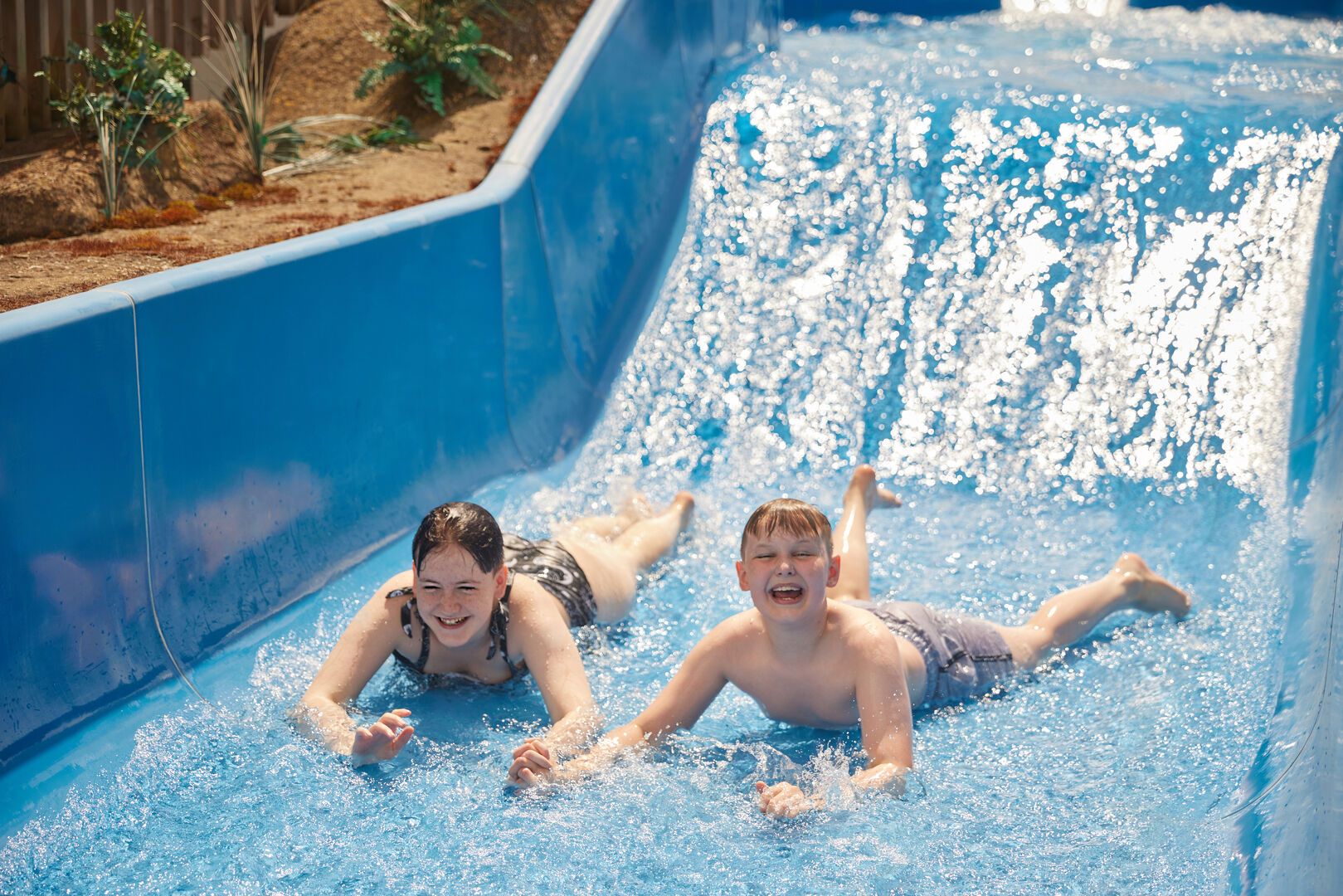 Two children going down the rapids together at Skegness Splash Waterworlds.