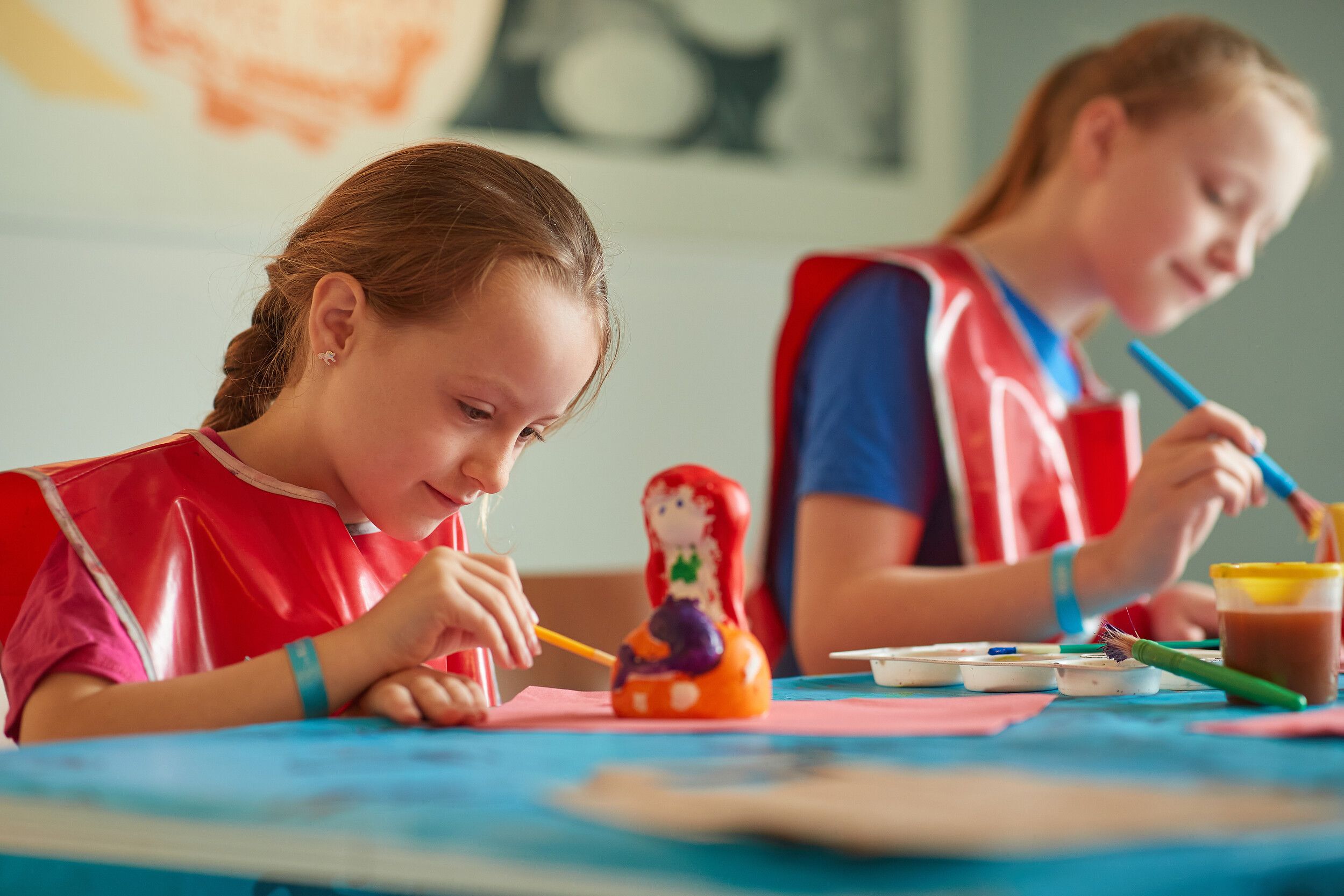 A girls enjoying pottery painting.