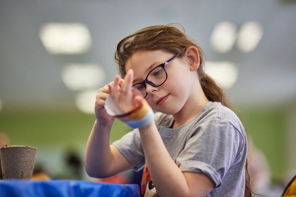A girl wearing some art material on her hands.