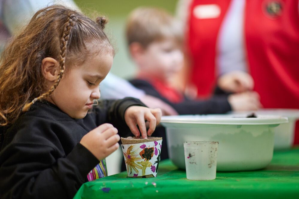 A little girl designing some pot art.
