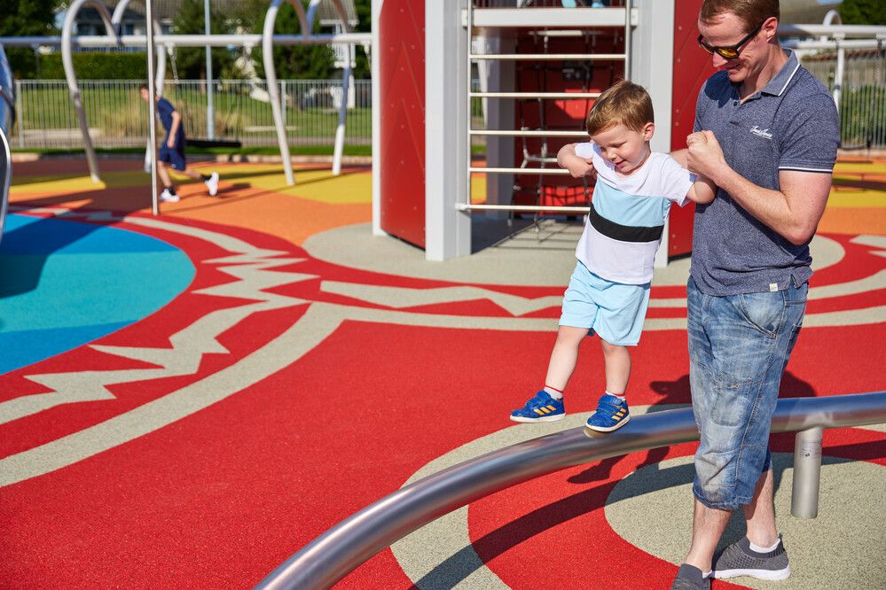 A young boy plays at Skypark with his father.