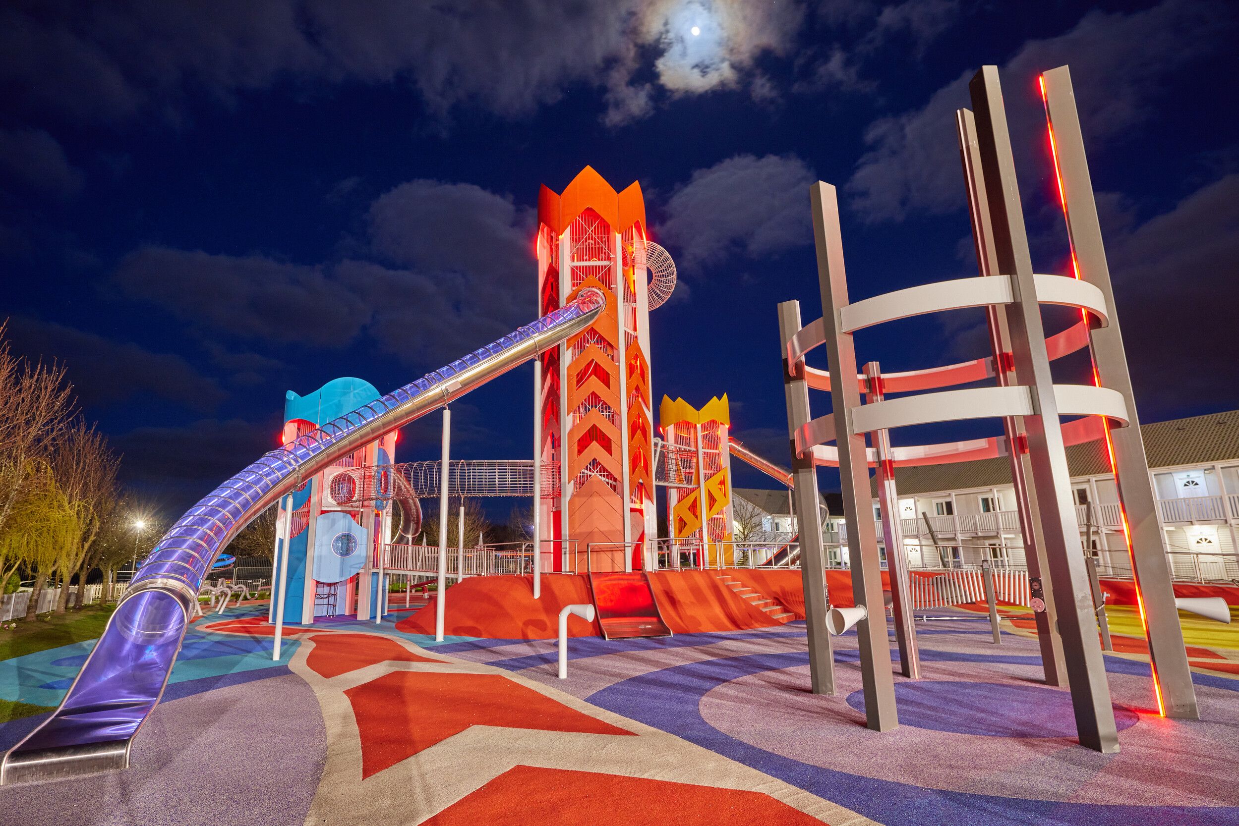 A view of the Skypark with colourful tower slides during the night.