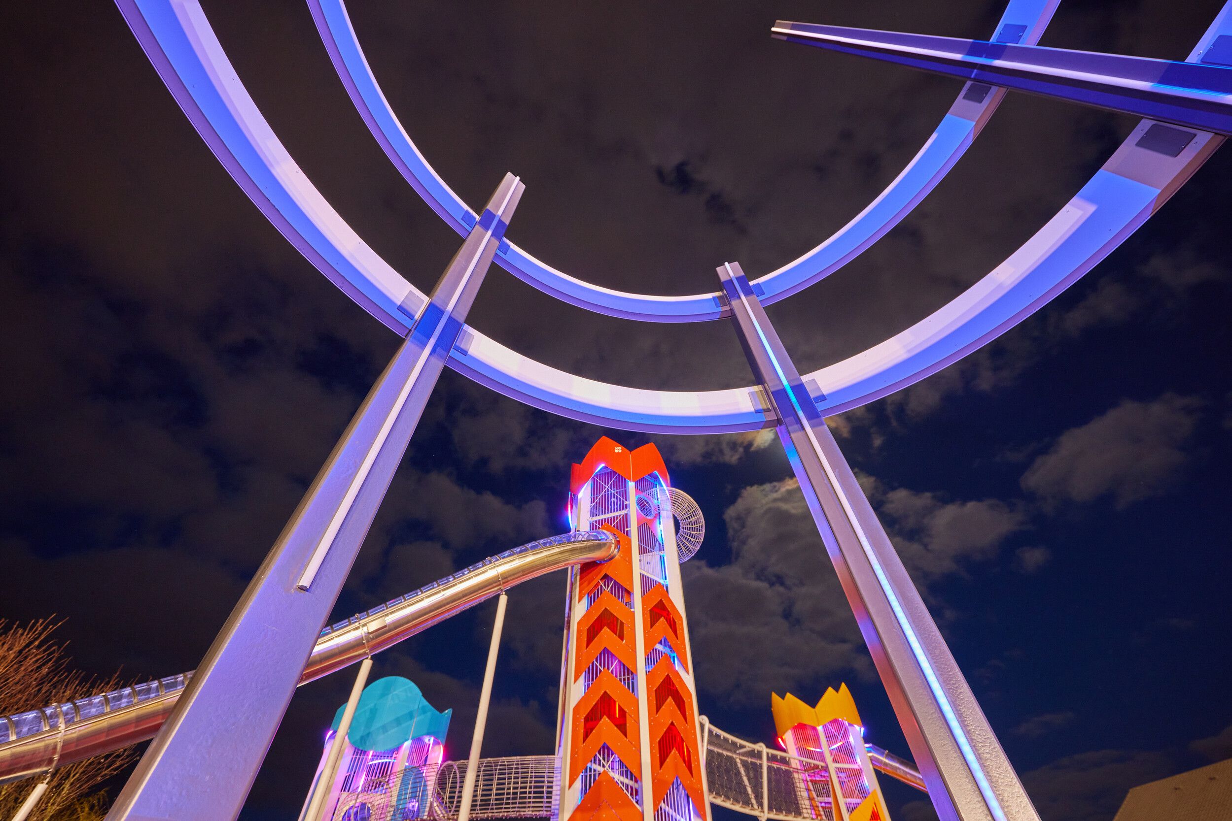 A view of the Skypark with colourful tower slides during the night.
