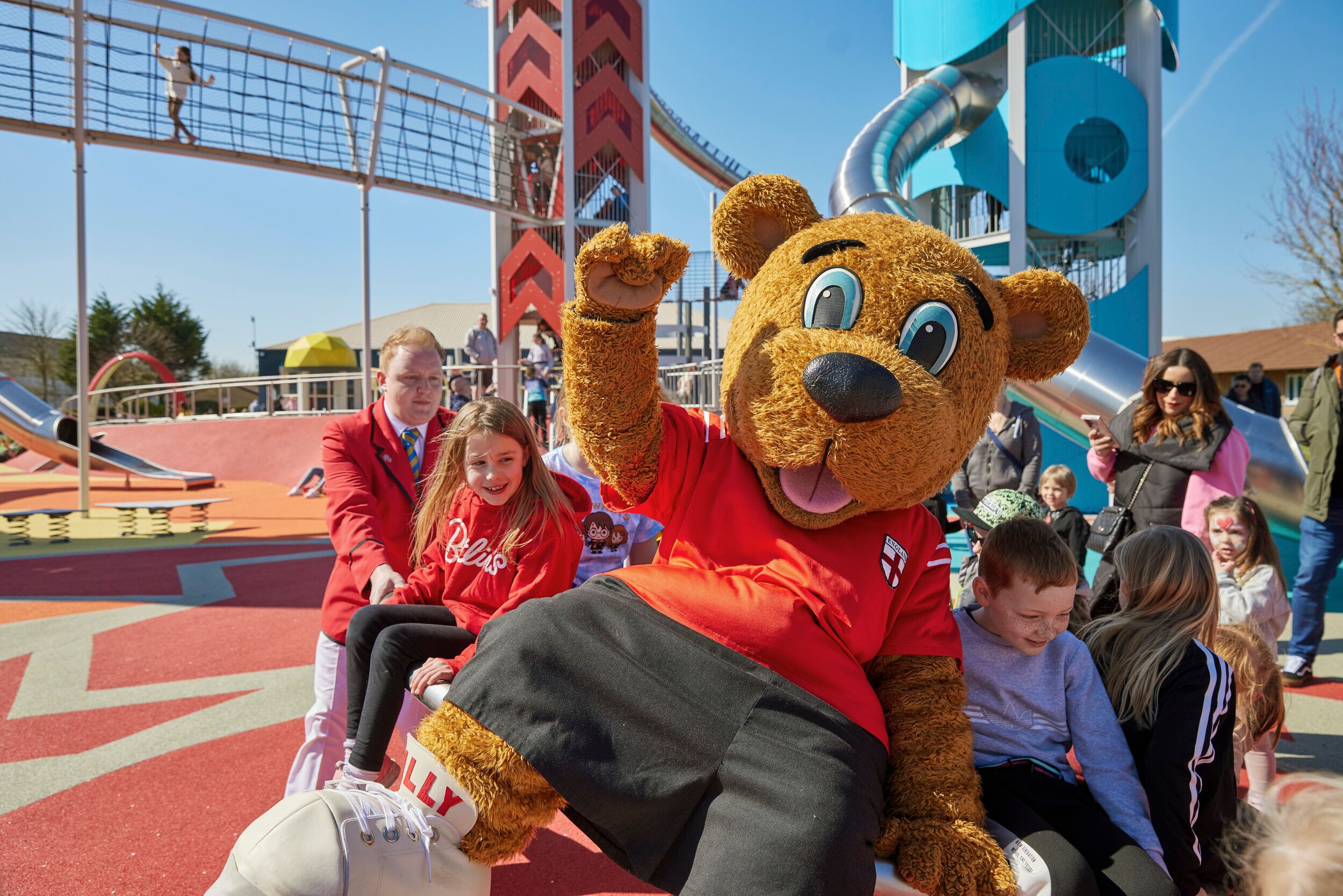 A Billy Bear mascot posing at the camera along with other kids.