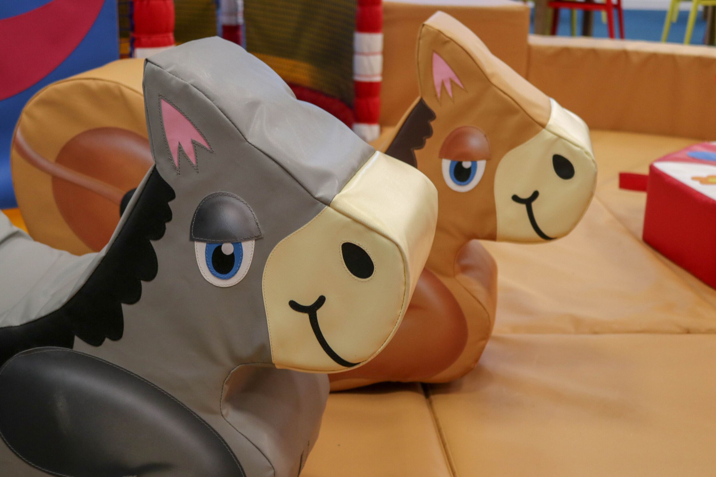 An indoor play area with horse designed seats.