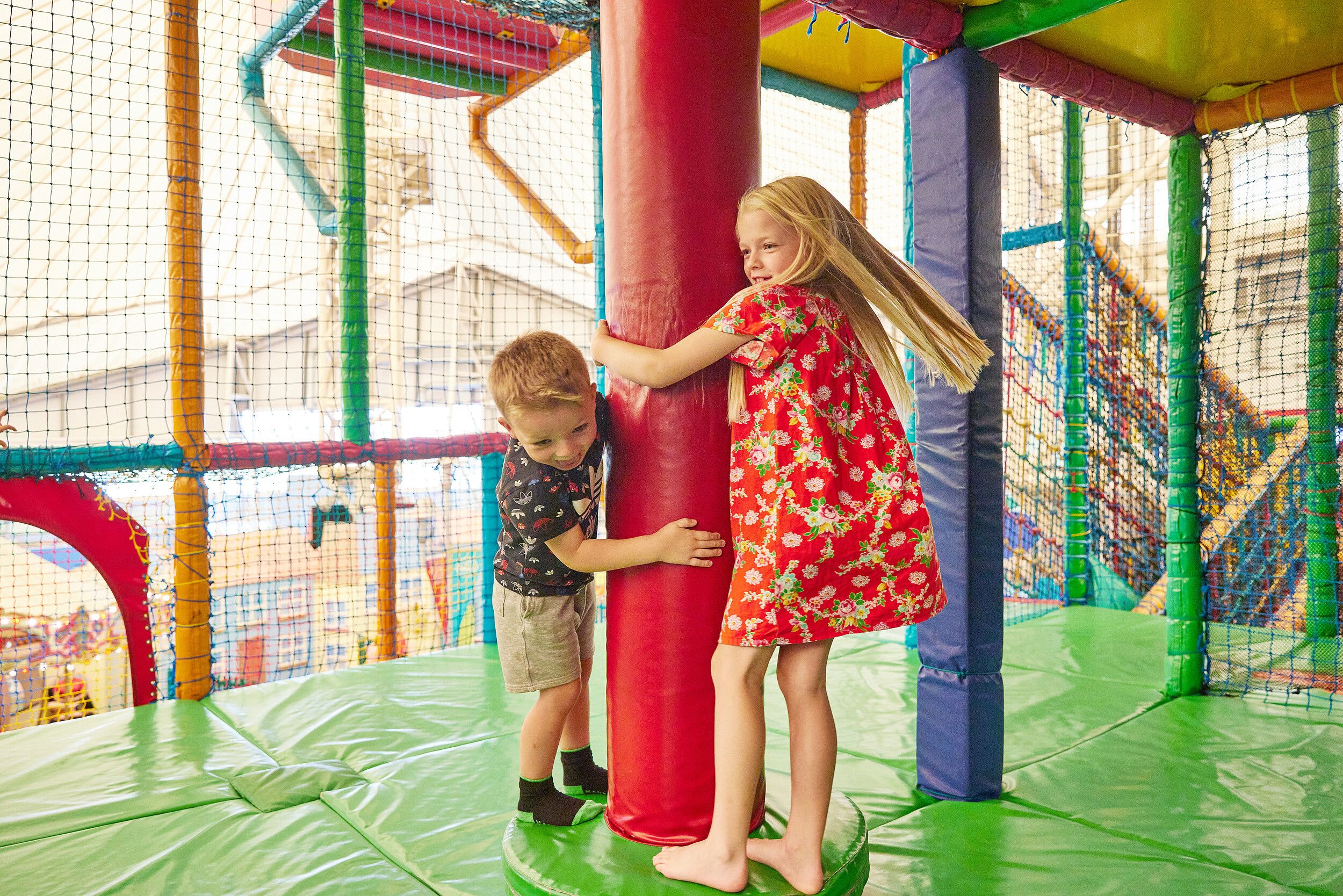 Two kids enjoying in a colourful playground.